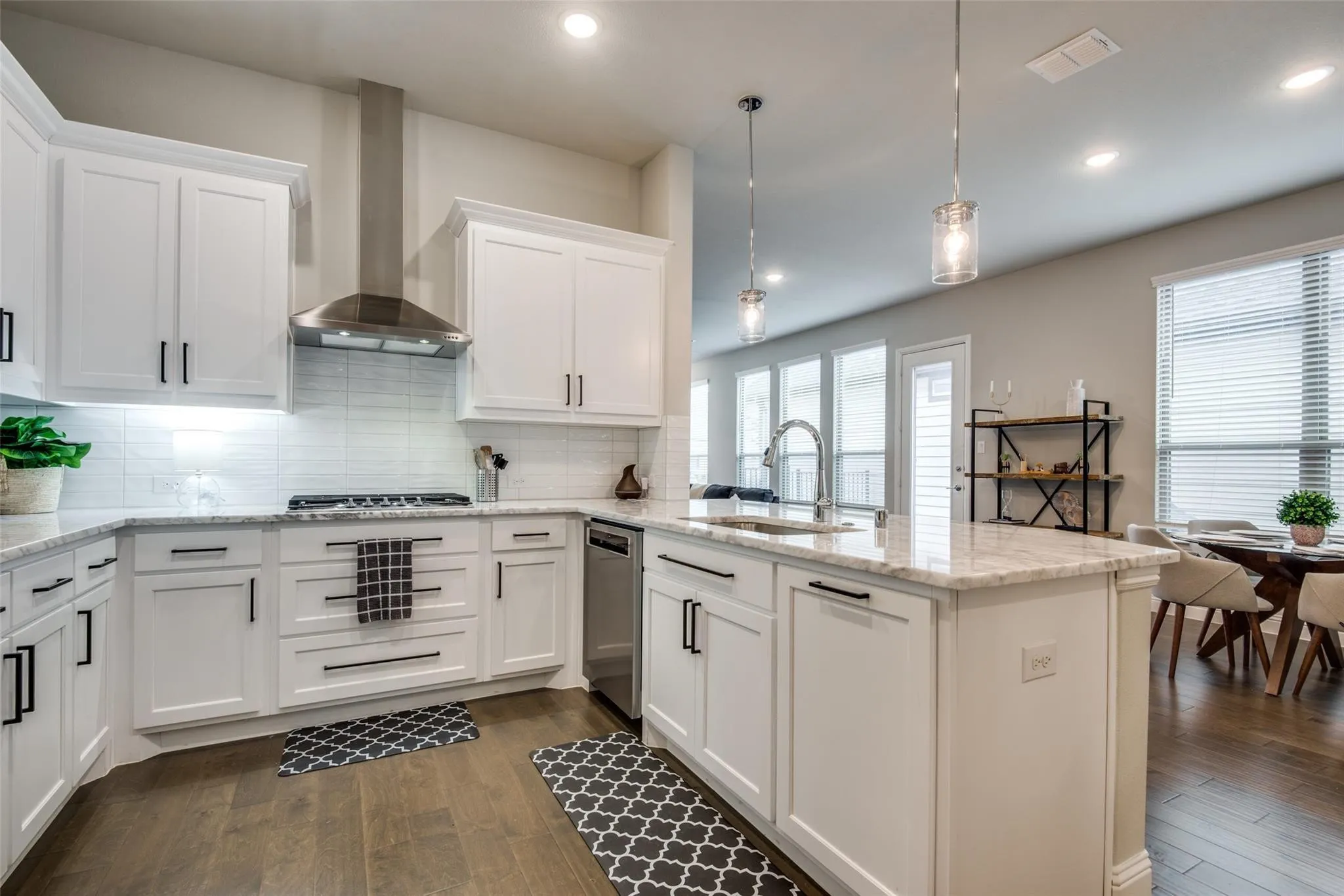 Sophisticated kitchen featuring white shaker cabinetry, stainless steel appliances, and a subway tile backsplash