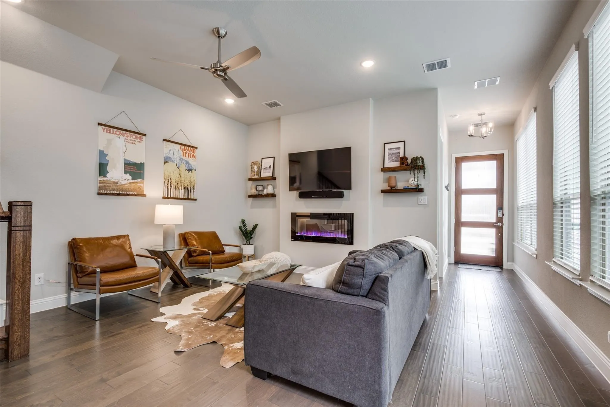 Modern living room showcasing wood-finish flooring, recessed lighting, and a ceiling fan