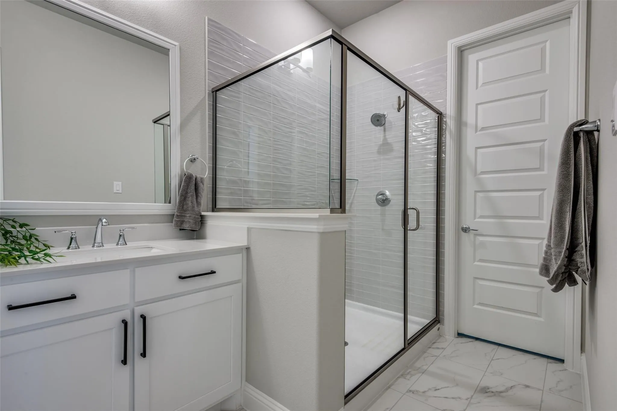 Contemporary bathroom featuring a spacious glass-enclosed shower with a textured tile surround