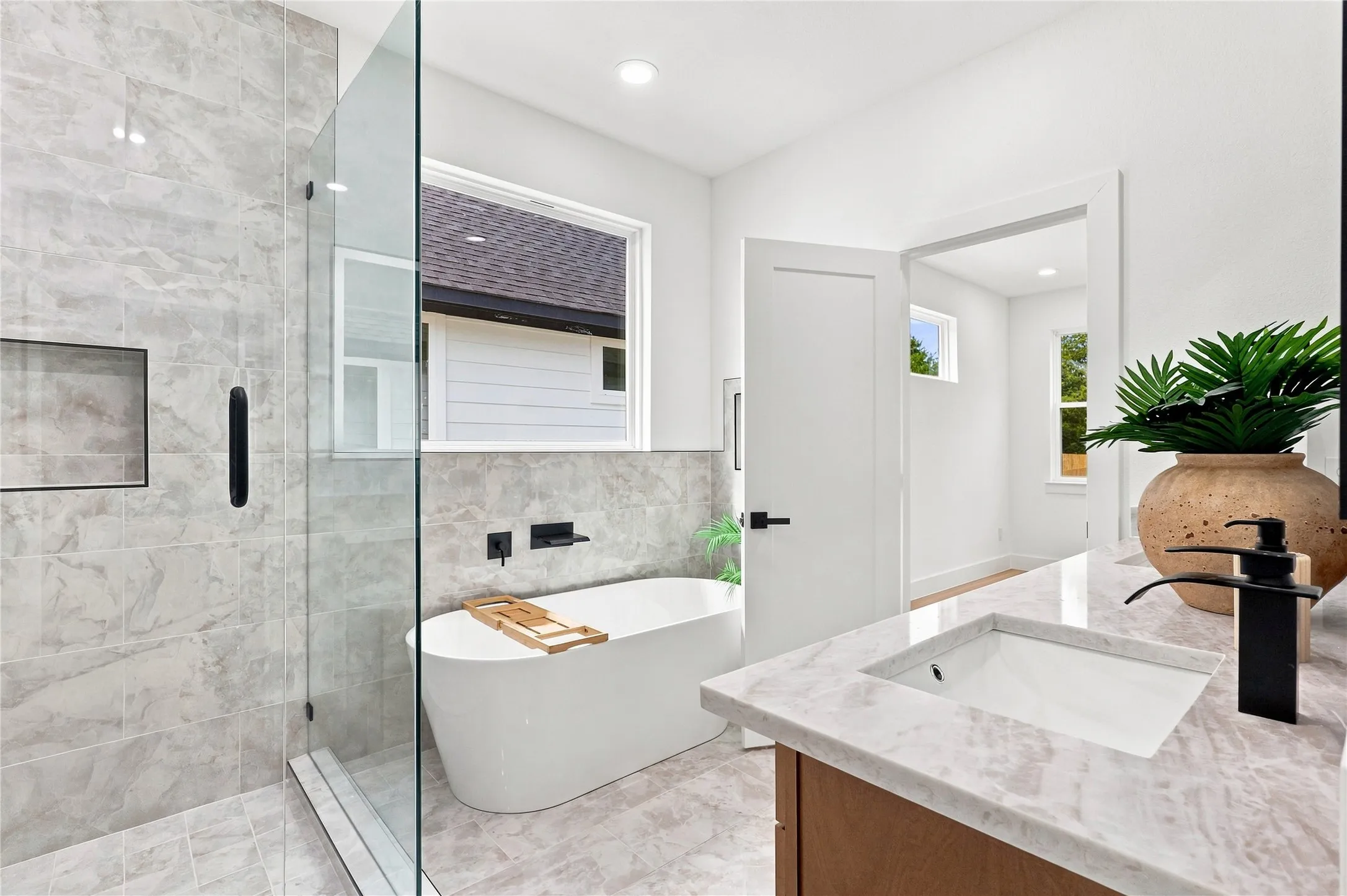 Unit A - Spacious Primary Bath featuring Dual Vanity, Freestanding Soaking Tub and Frameless Shower