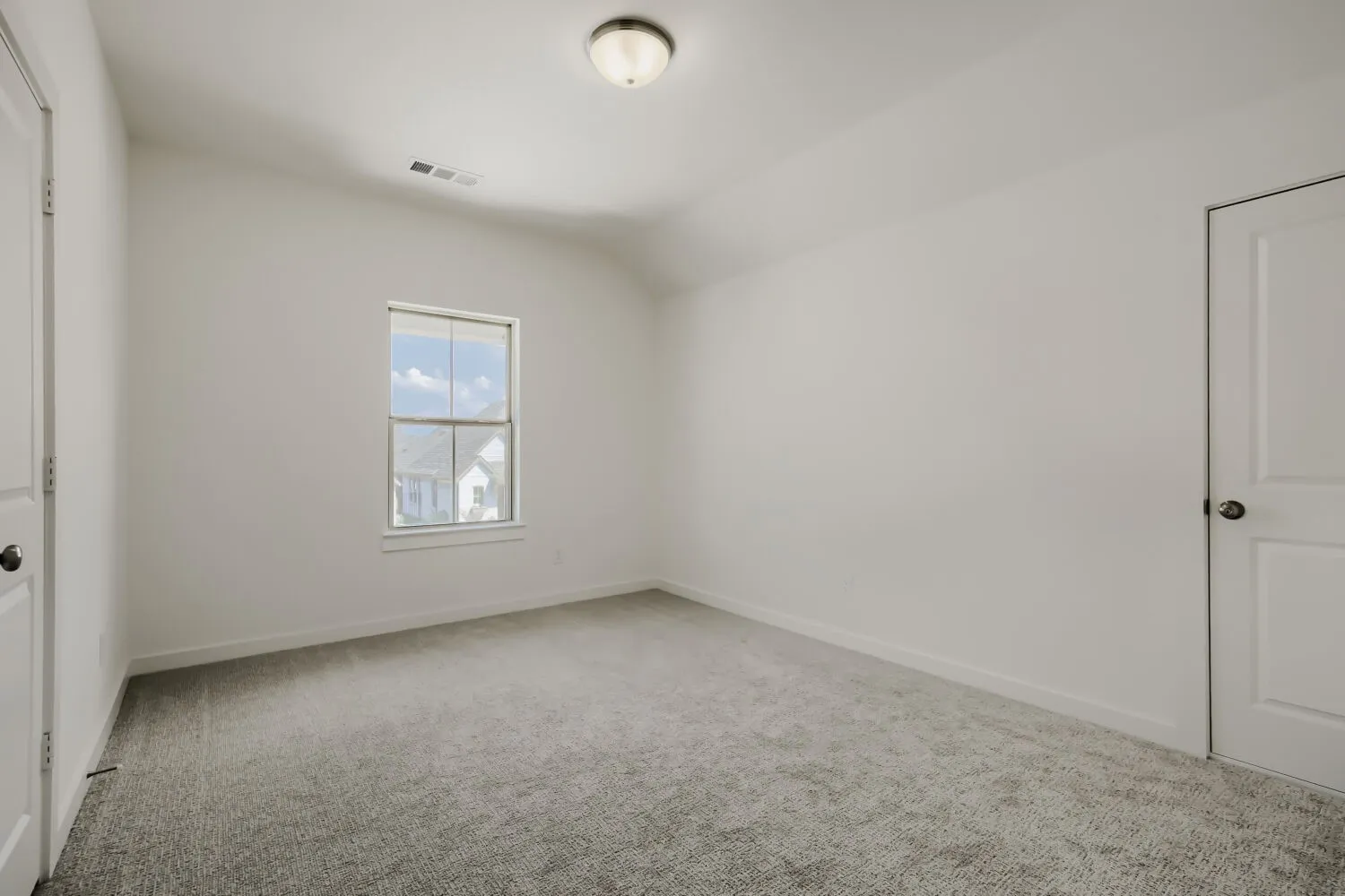 Neutral tone wall paint, light gray carpeting, flush-mount ceiling light fixture, and white interior doors