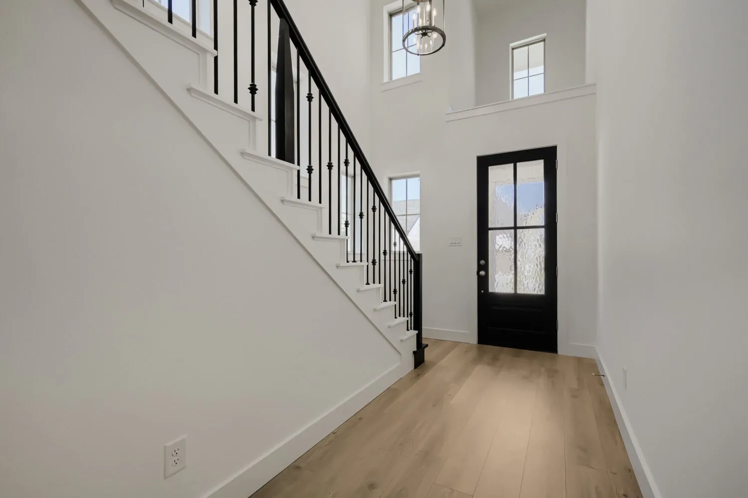 Entryway featuring a black-framed glass door, high ceilings, and wood-finish flooring