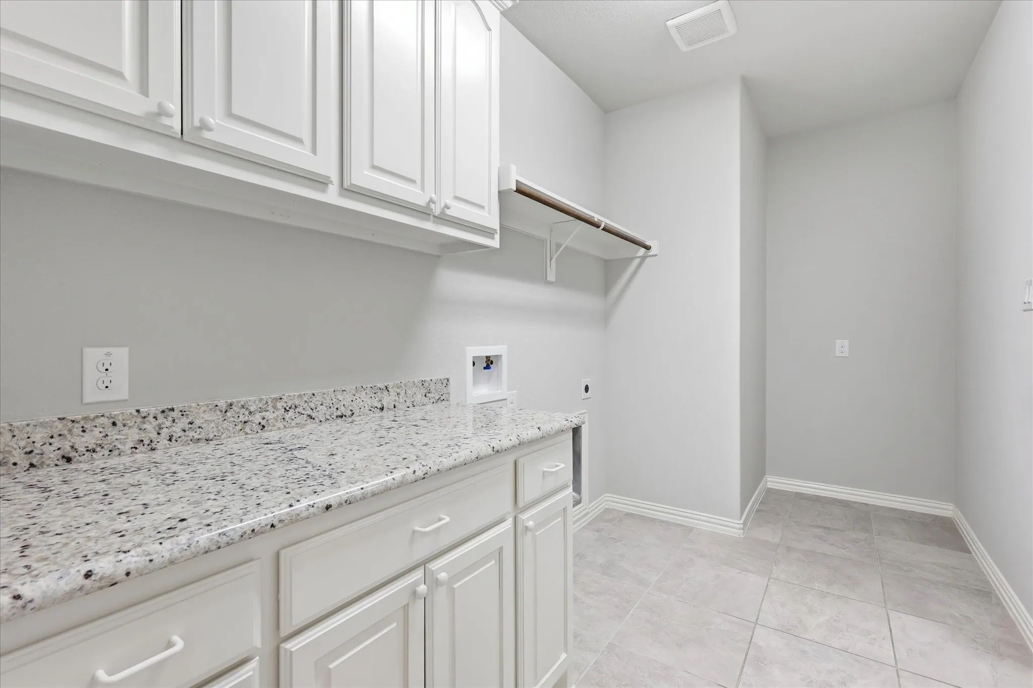 Laundry room featuring light-colored tile flooring
