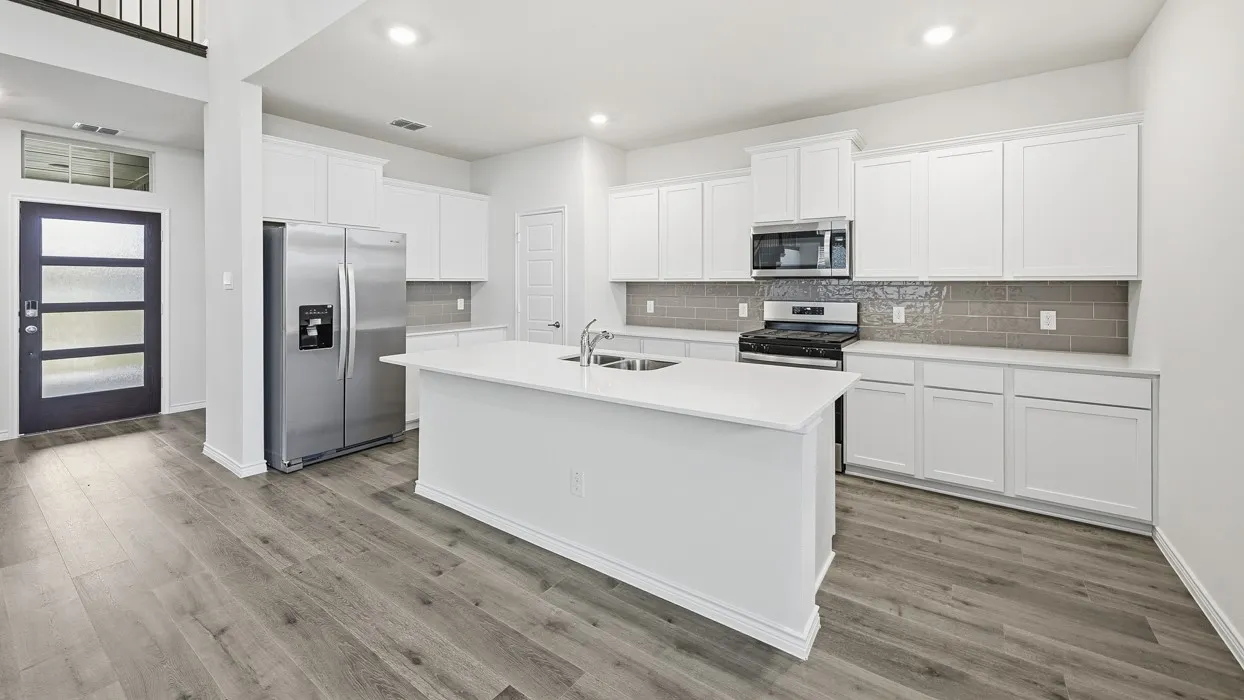 Modern kitchen featuring white shaker cabinetry, stainless steel appliances, a center island with sink, and wood-finish flooring