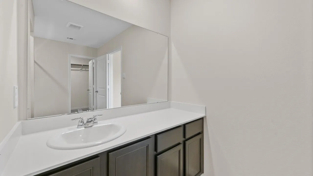Vanity featuring a white countertop with an integrated sink and chrome faucet