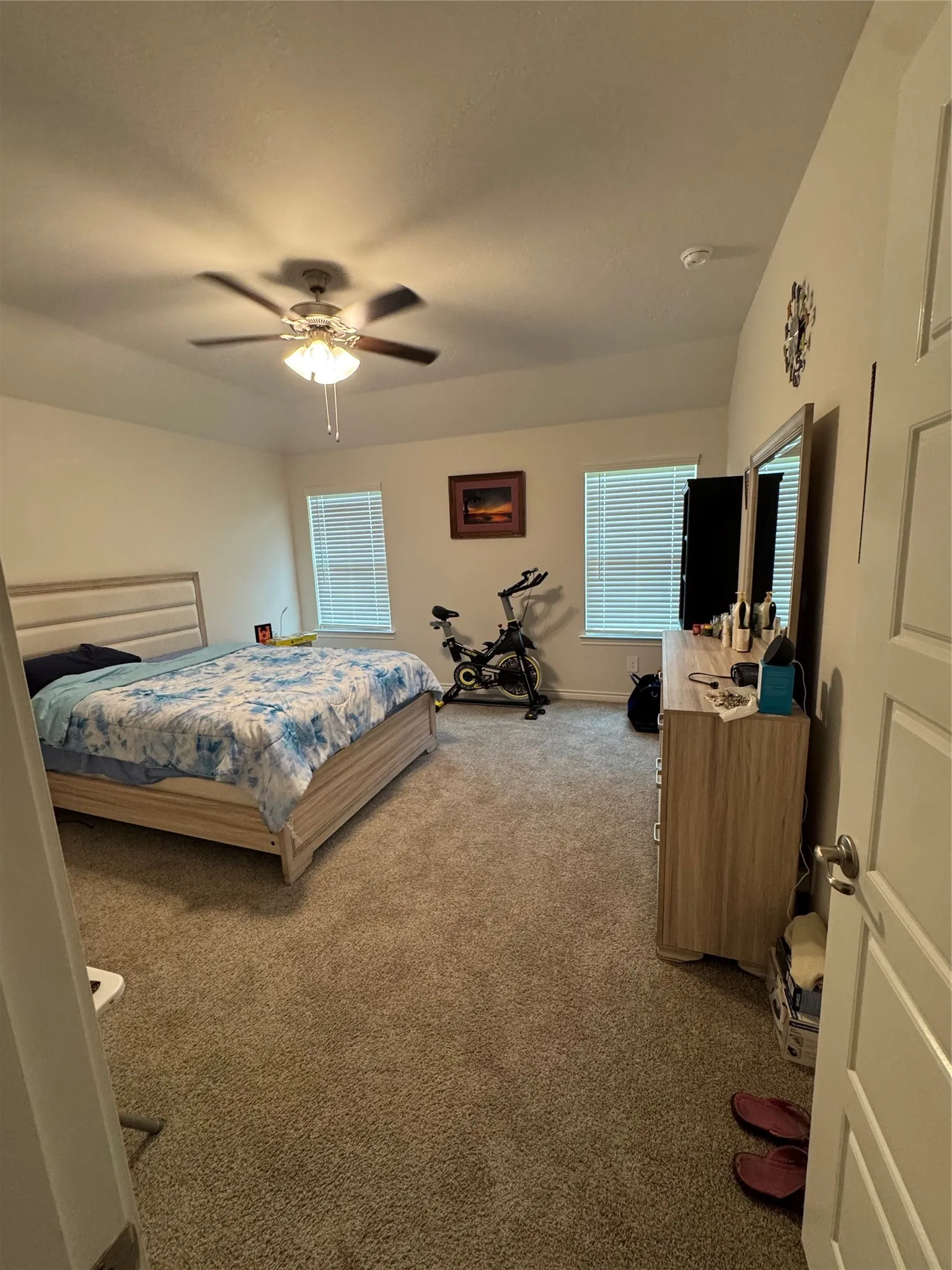 Carpeted bedroom with ceiling fan and baseboards