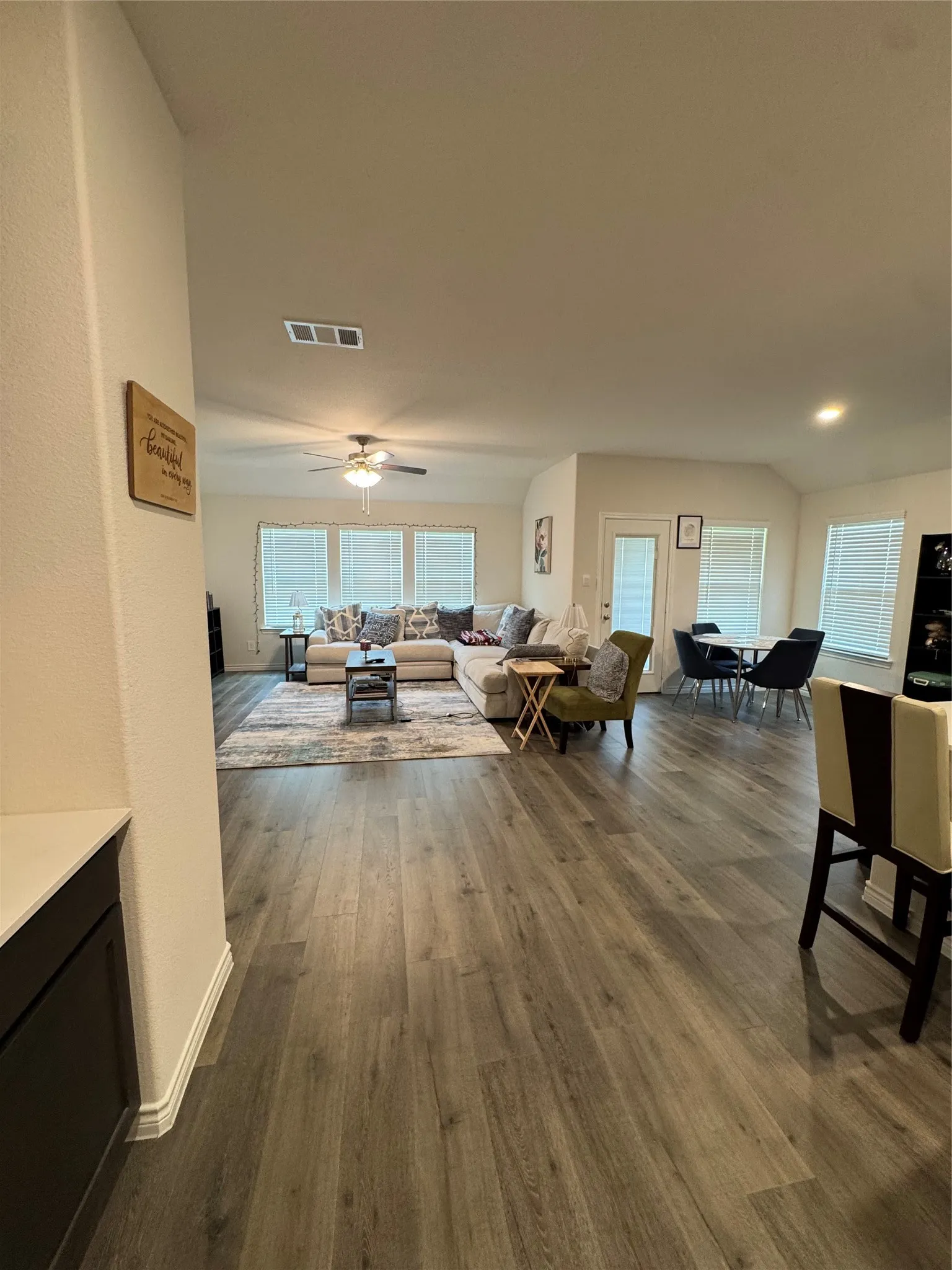 Living area with dark wood finished floors and ceiling fan