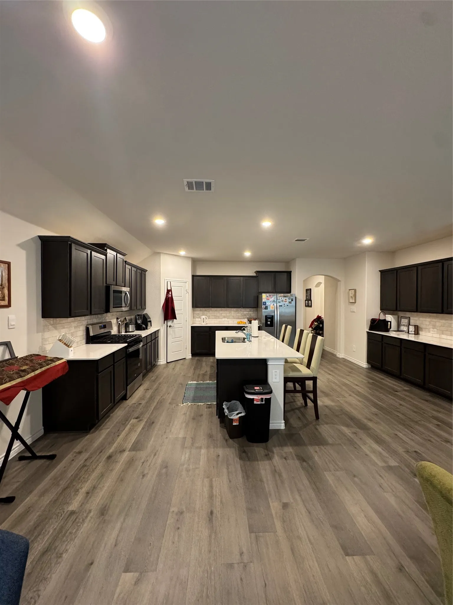Kitchen with range, fridge, tasteful backsplash, arched walkways, and recessed lighting