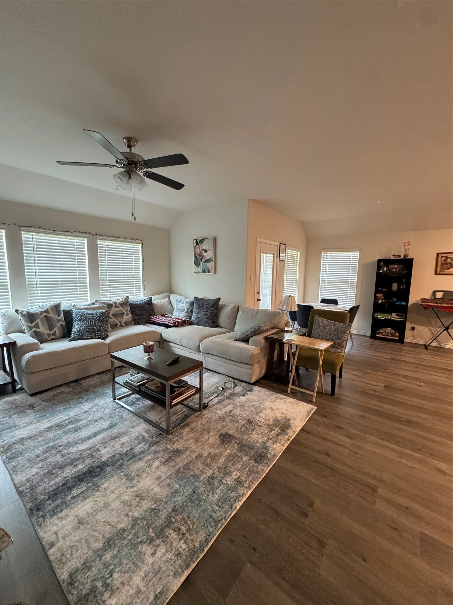 Living room featuring wood finished floors, plenty of natural light, and a ceiling fan