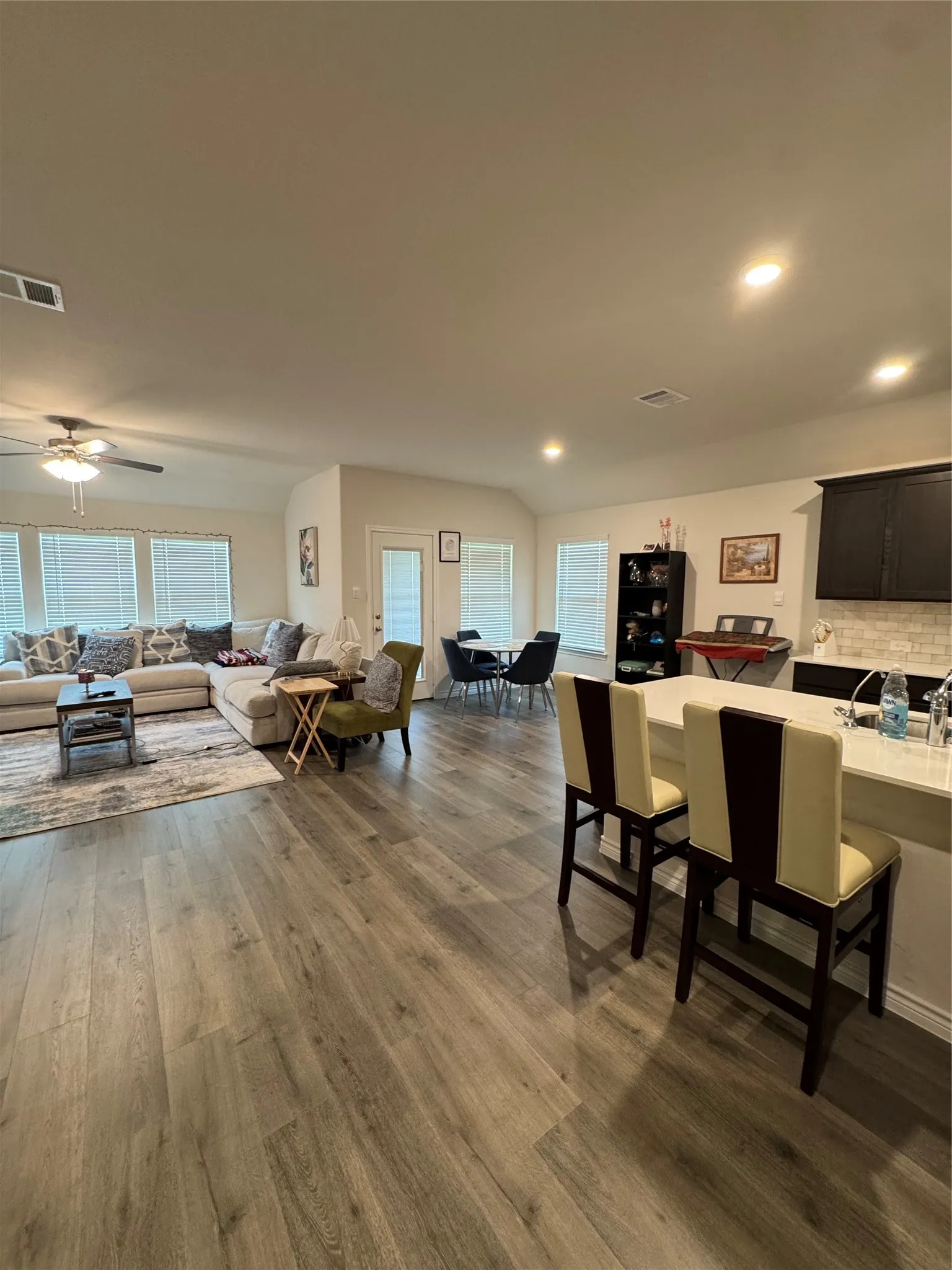Dining area featuring dark wood-style flooring, ceiling fan, and recessed lighting