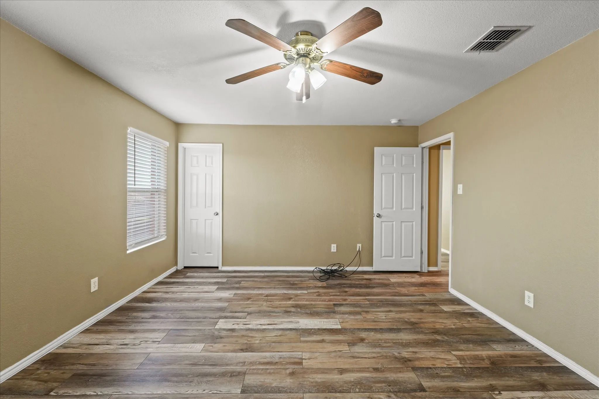 Unfurnished bedroom with wood finished floors, a ceiling fan, and a closet