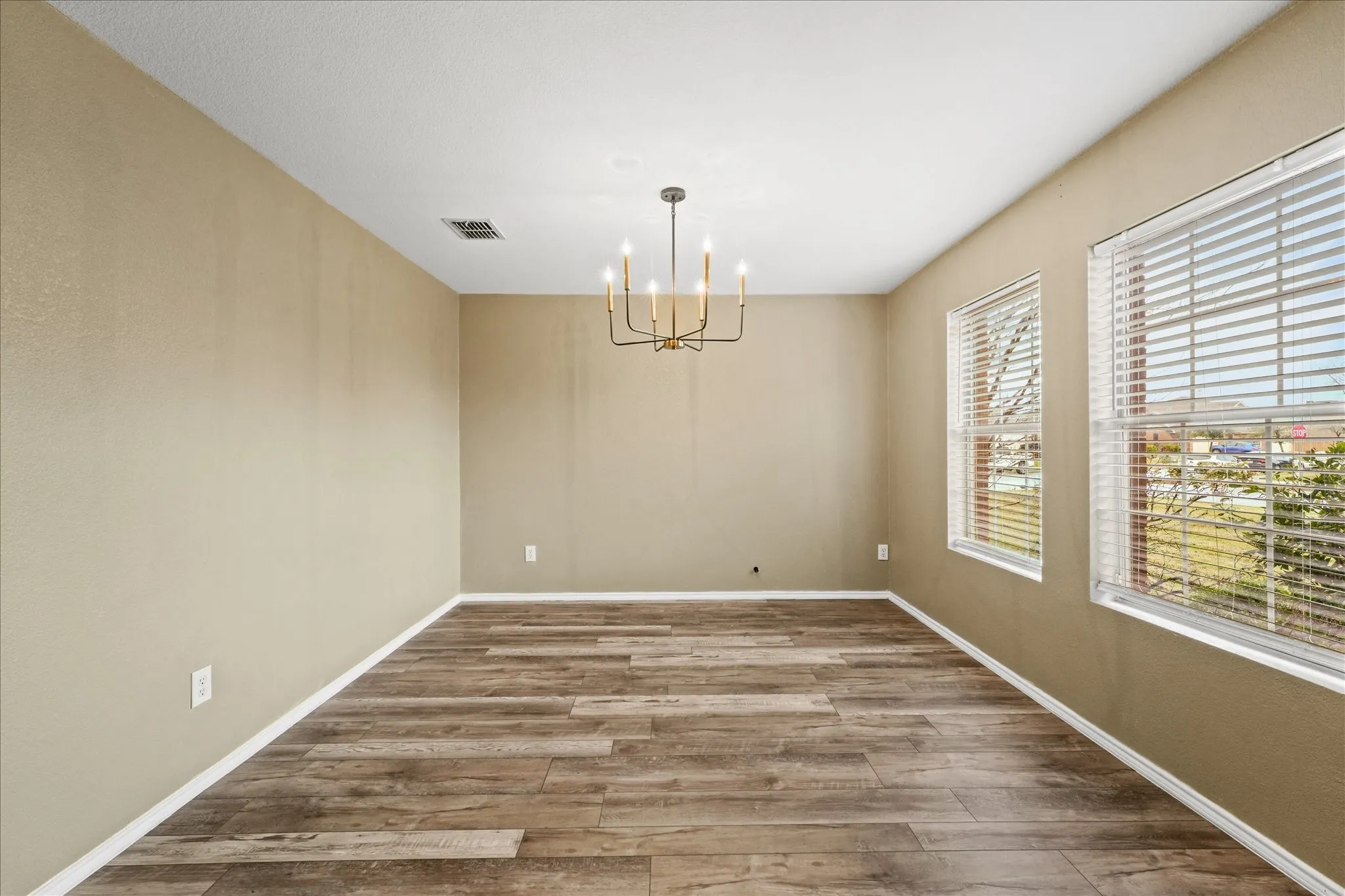 Unfurnished room featuring a chandelier and wood finished floors