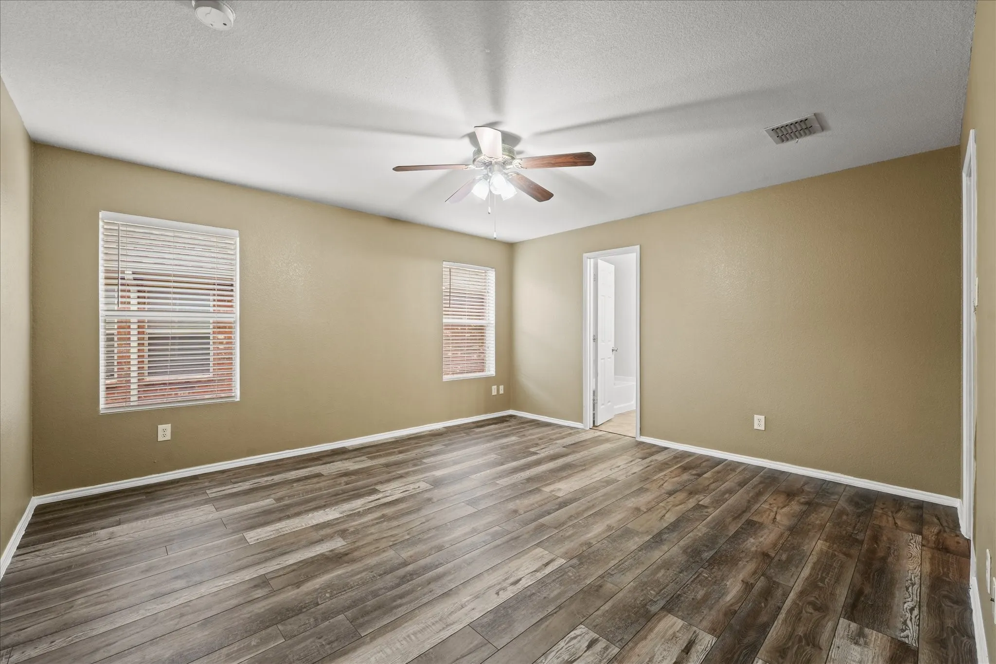 Spare room featuring ceiling fan, dark wood-style flooring, a smoke detector, and a textured ceiling