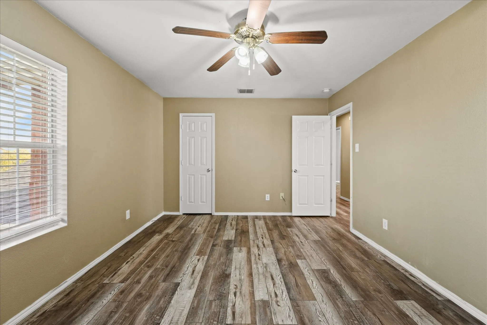 Unfurnished bedroom featuring wood finished floors and a ceiling fan
