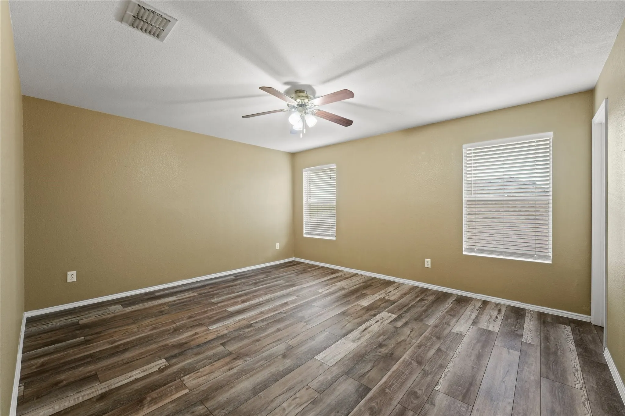 Empty room featuring ceiling fan and dark wood-style floors