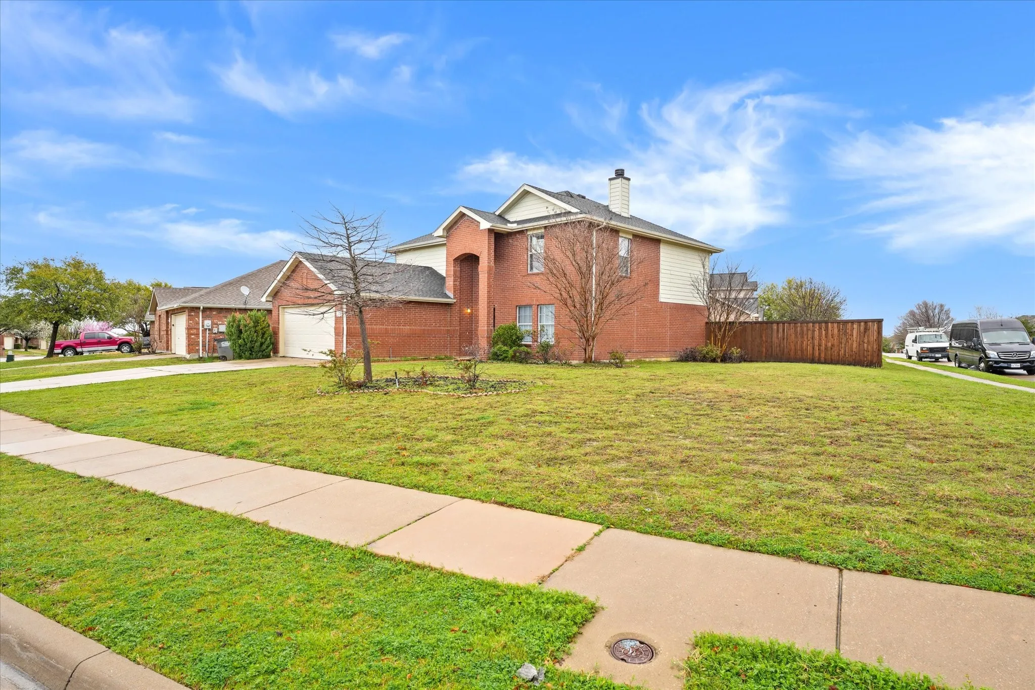 Traditional-style home with brick siding, concrete driveway, a chimney, and an attached garage