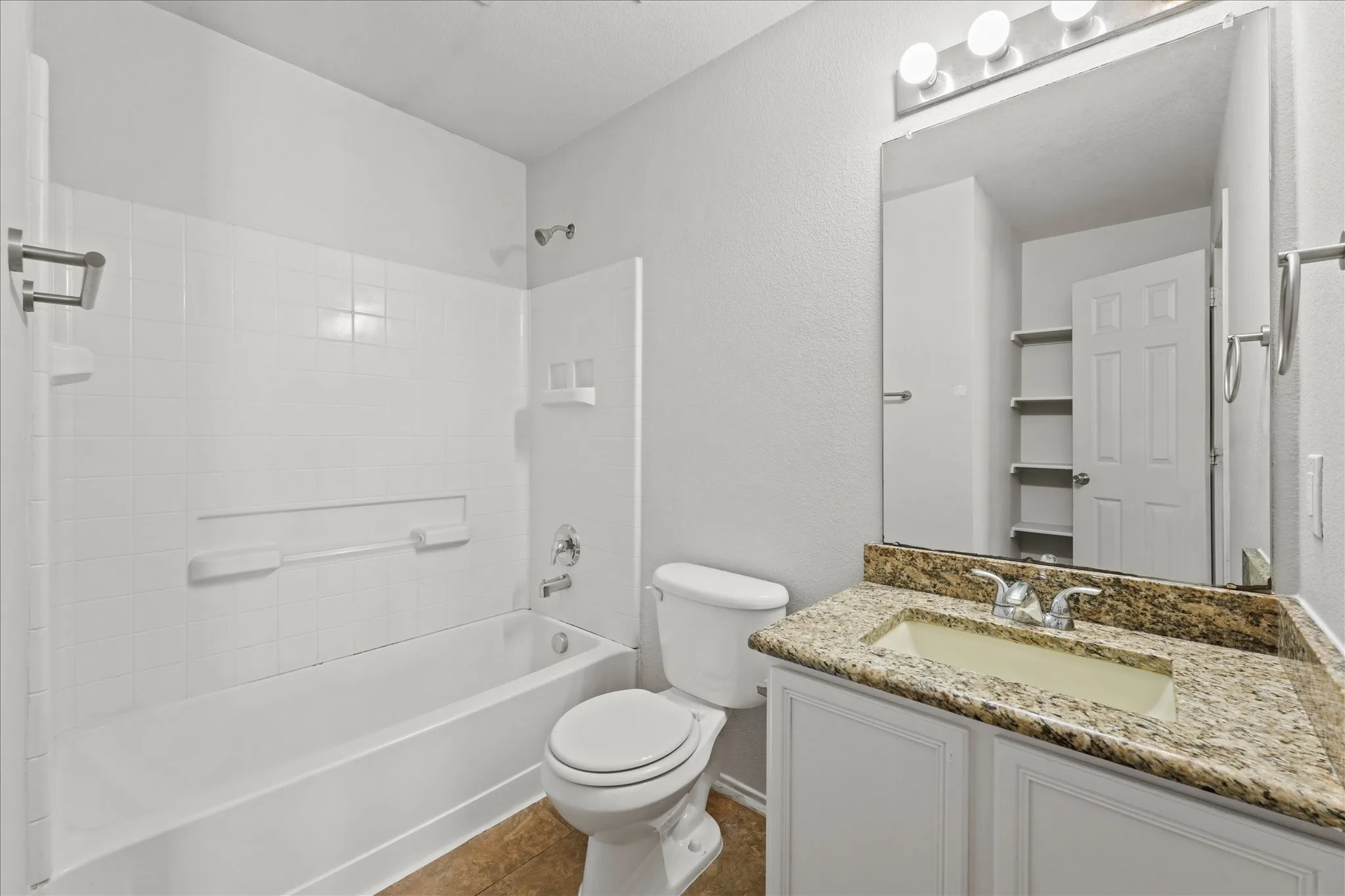 Full bath featuring vanity, shower / bathtub combination, and tile patterned flooring