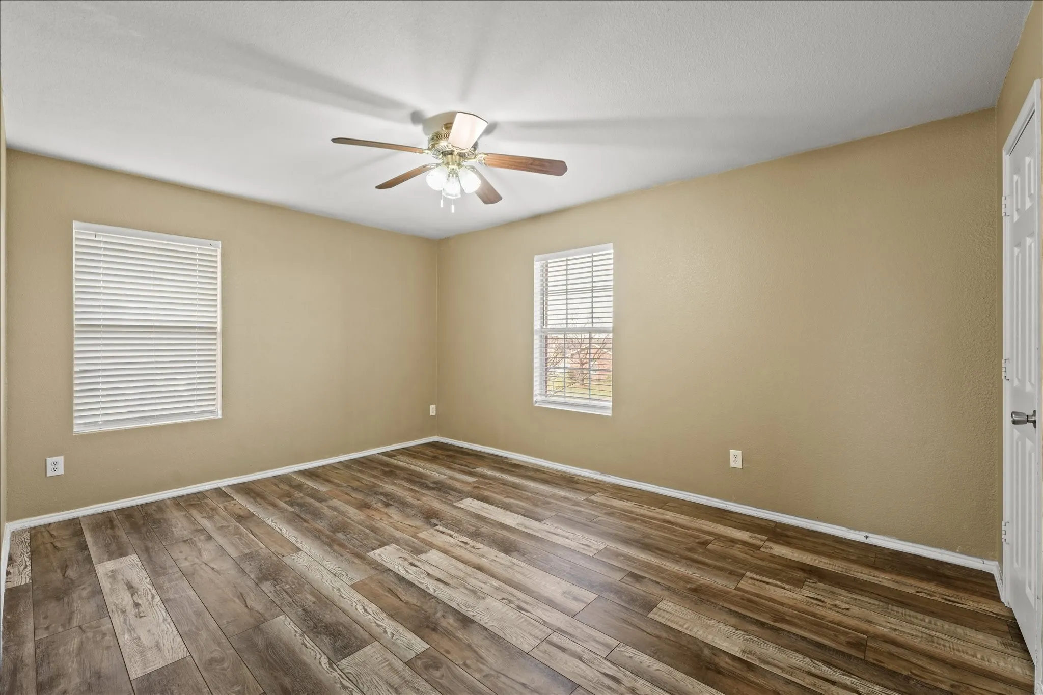 Spare room featuring a ceiling fan and dark wood-style floors
