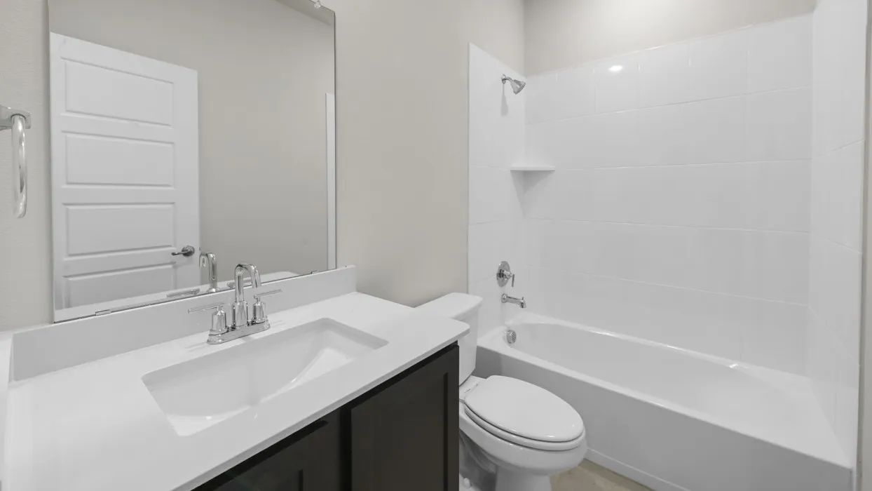 Modern bathroom featuring a sleek vanity with an integrated rectangular sink, white quartz countertop, and chrome faucet hardware
