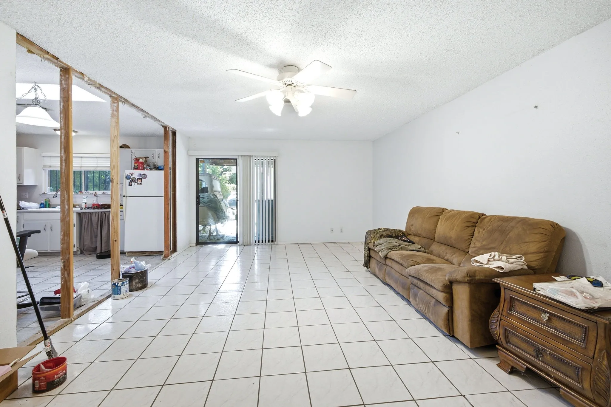 Open living space view displaying tiled floors, mirrored closet doors, and light neutral tones.