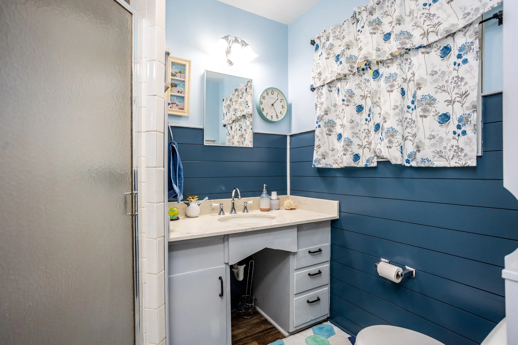 Compact with shower and vanity featuring some storage.