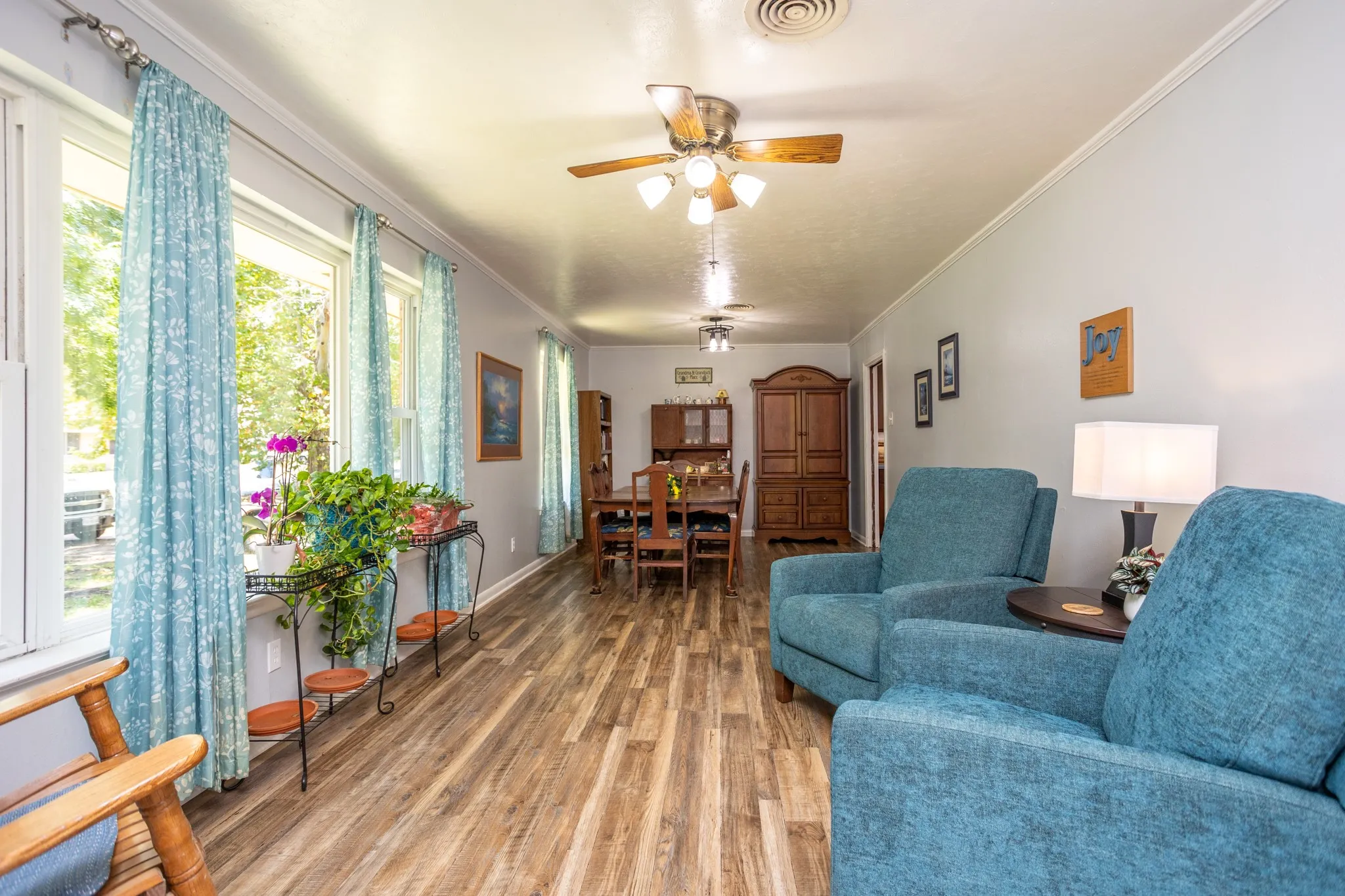 Spacious living dining combo with large windows for light, laminated wood floors though out.