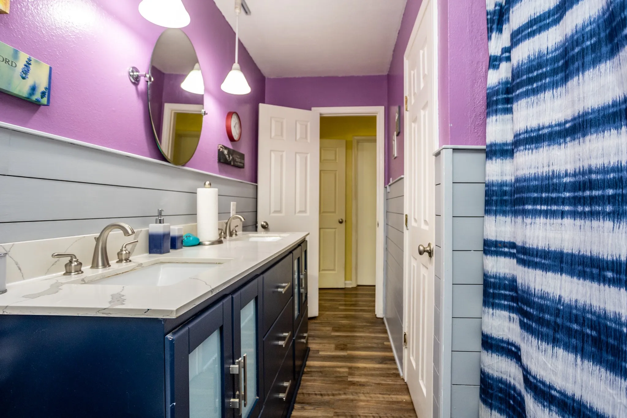 Hall bath has large vanity with storage and the owner's daughter's favorite purple walls.  Tub shower combo.  Linen storage.