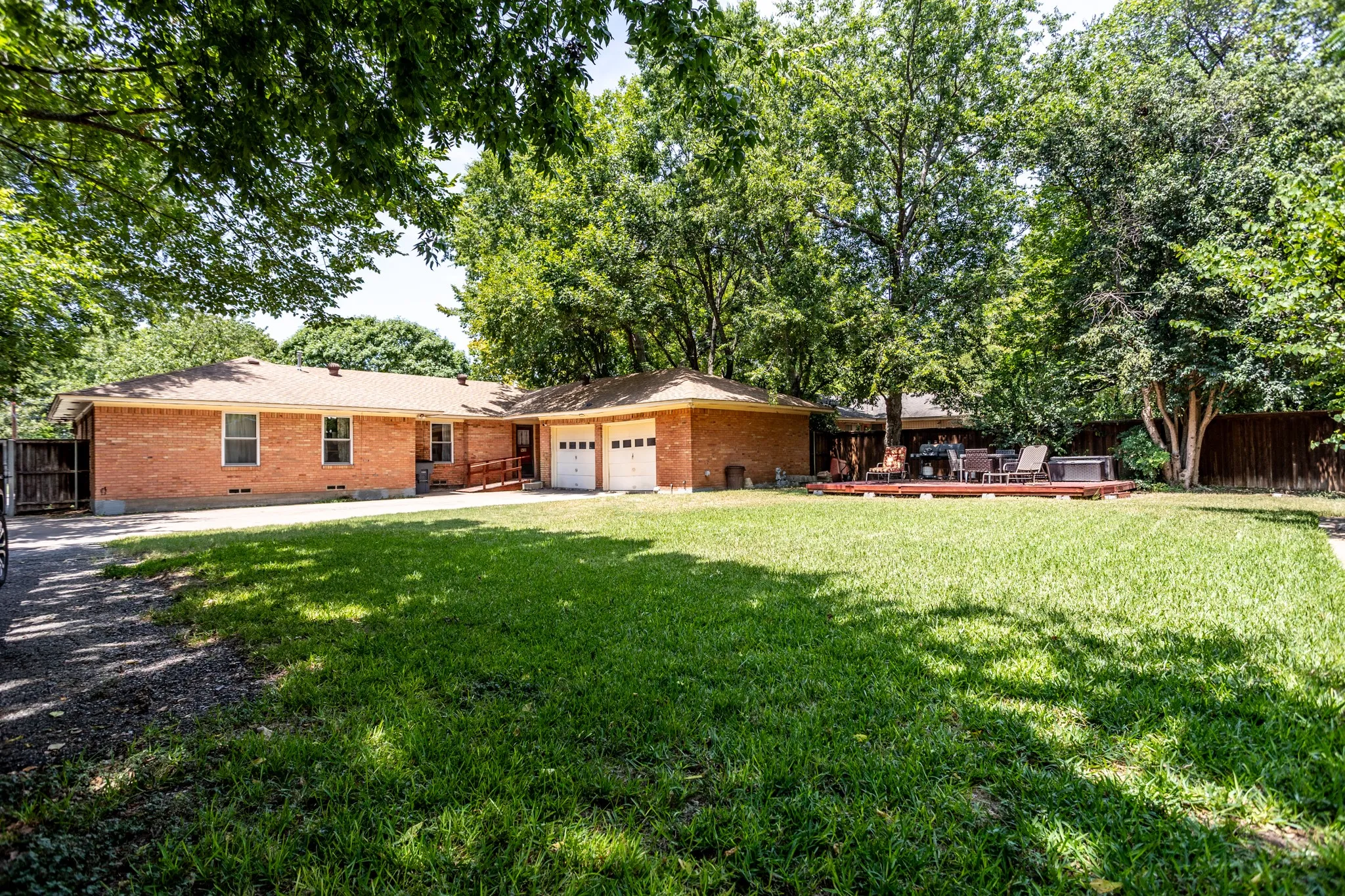 View shows trees and inviting wood deck for outdoor entertainment and family gatherings.