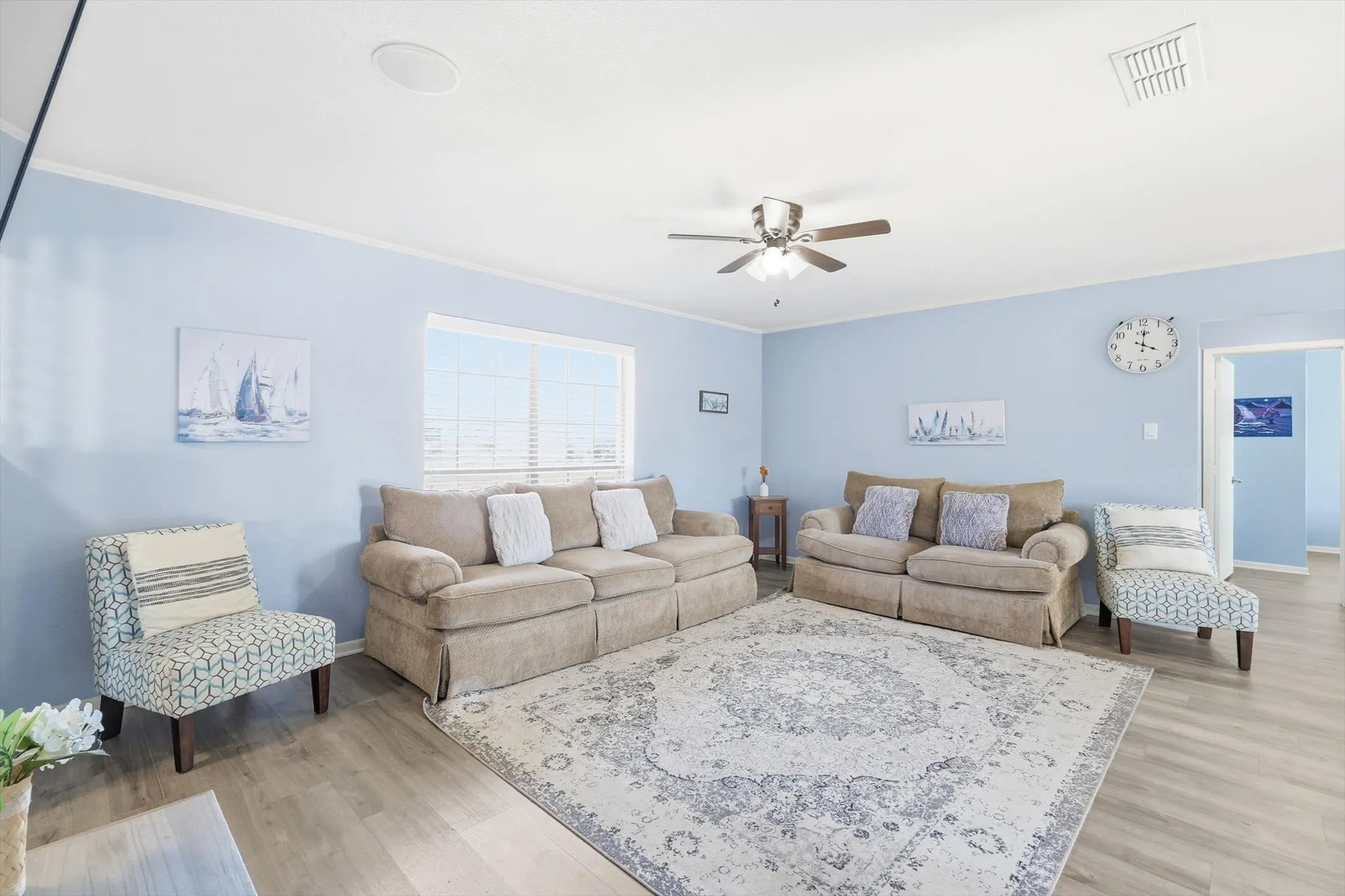 Large furnished living space with ceiling fan, new flooring and plenty of space!