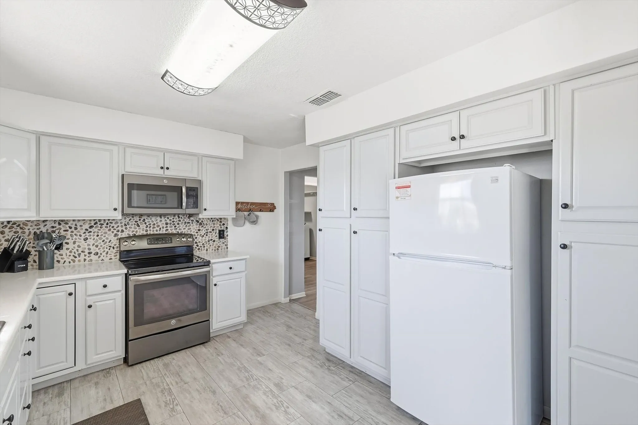 Gorgeous painted cabinets, new countertops, flooring, and backsplash!