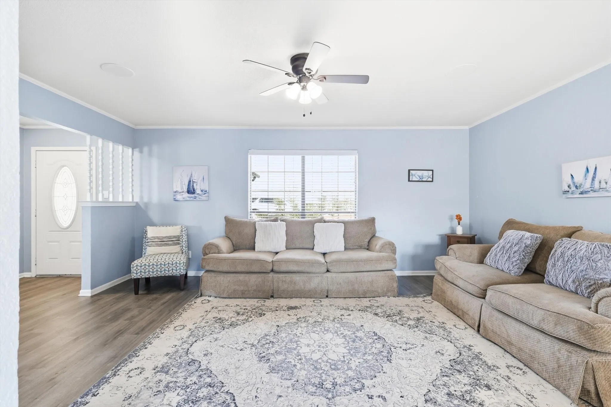 Living area featuring ornamental molding, wood finished floors, and a ceiling fan