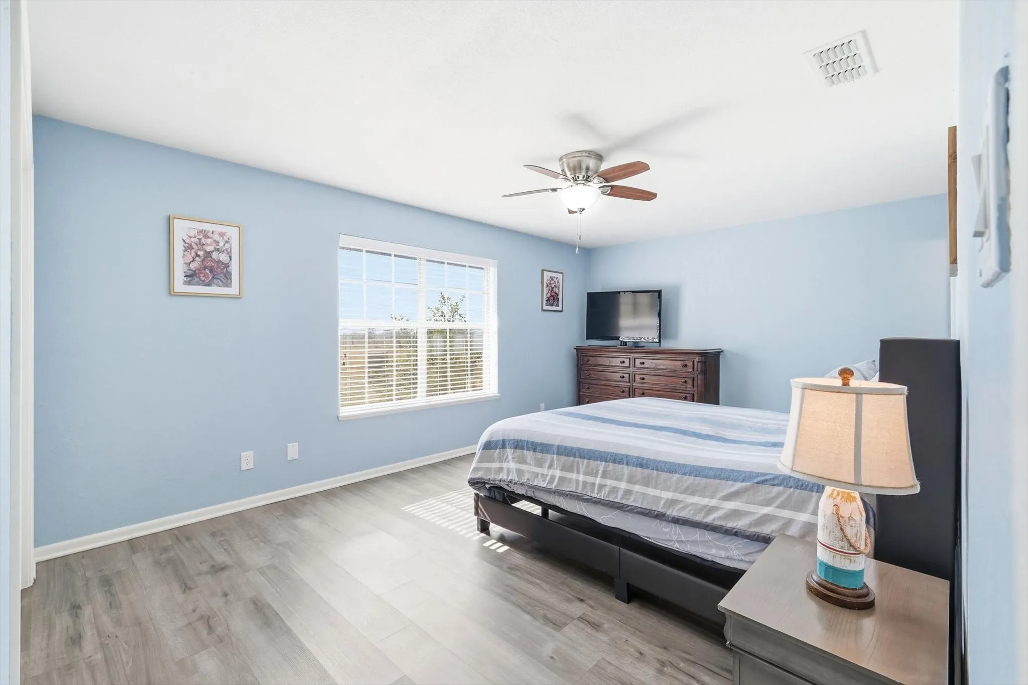 Large primary bedroom with new flooring, ensuite bathroom and ceiling fan!