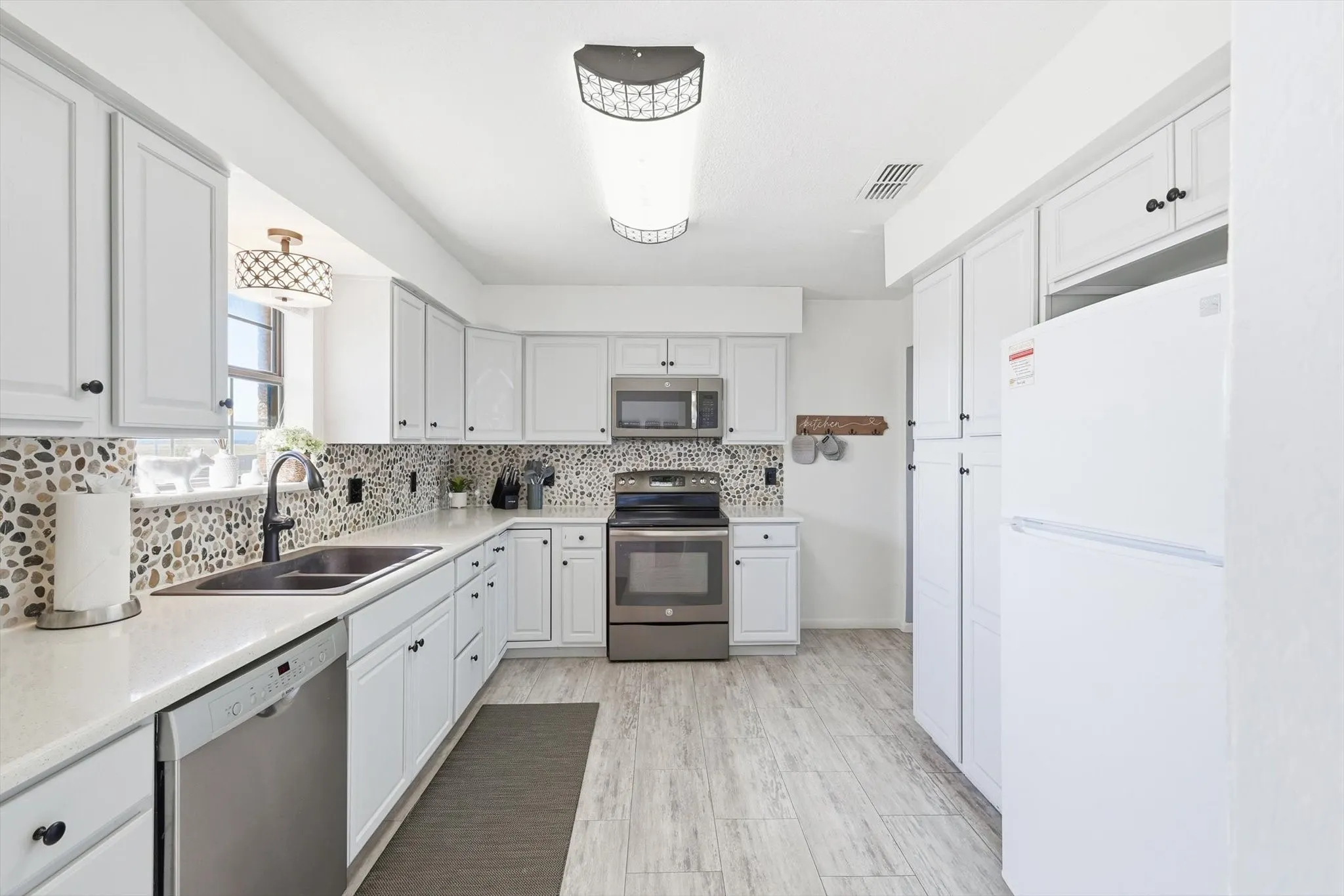 Gorgeous painted cabinets, new countertops, flooring, and backsplash!