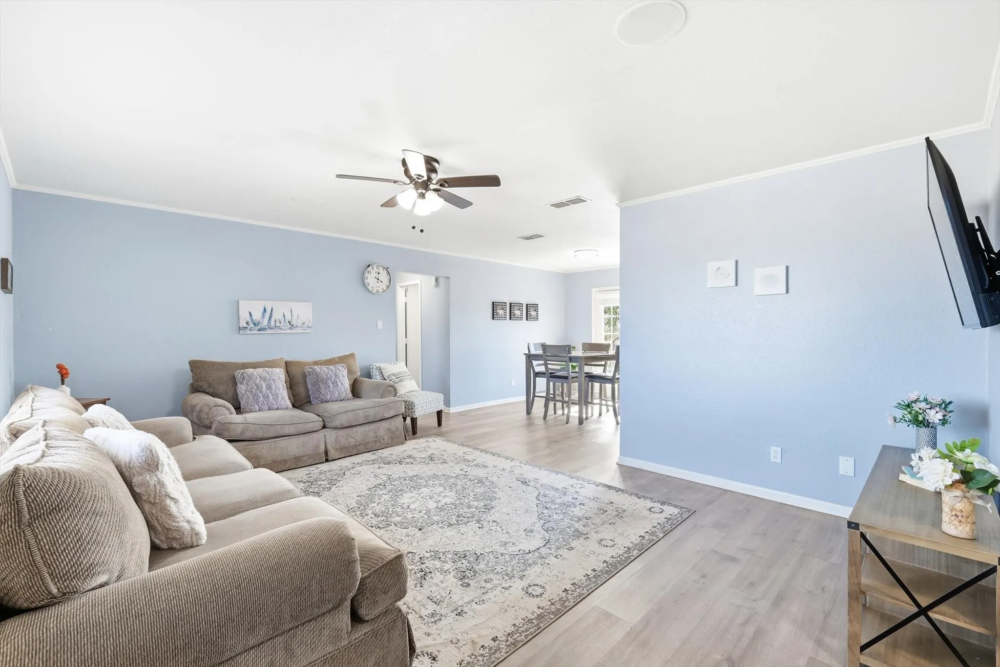Large furnished living space with ceiling fan, new flooring and plenty of space!