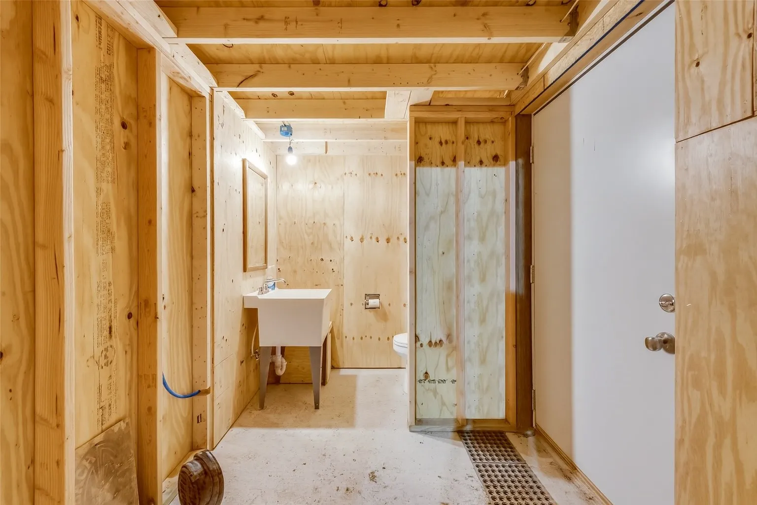 Half bathroom with toilet and vanity in building.