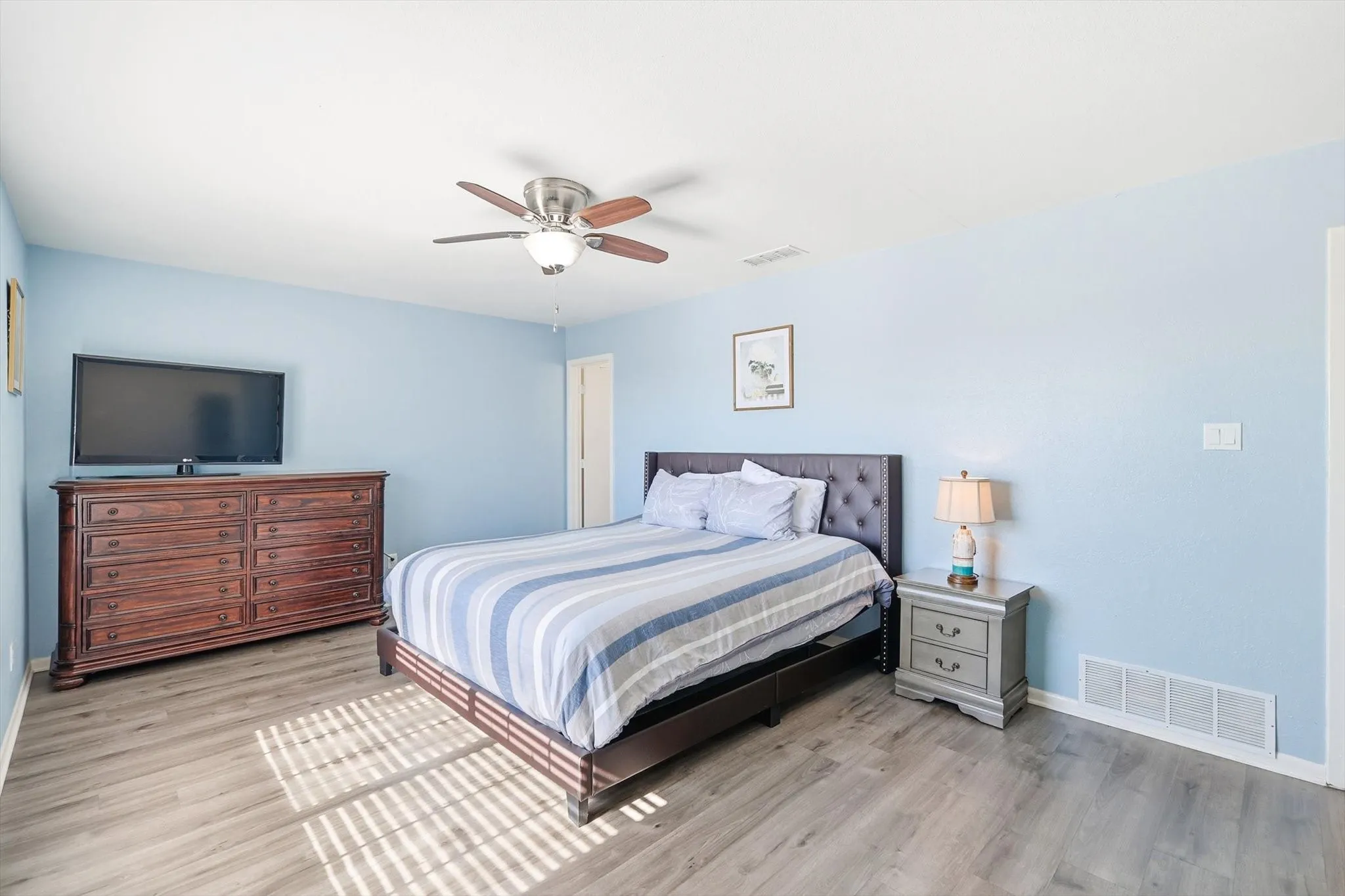 Large primary bedroom with new flooring, ensuite bathroom and ceiling fan!