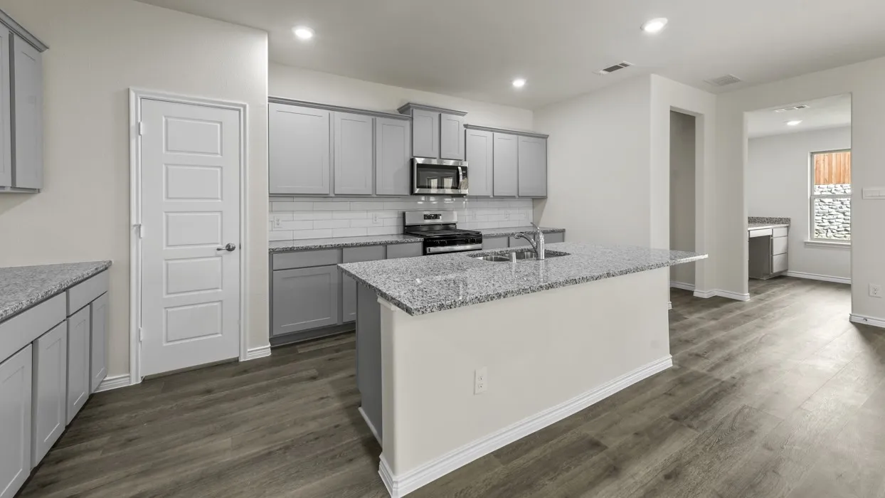 Open-concept kitchen featuring an island with a breakfast bar, stainless steel appliances, grey cabinetry, and granite countertops