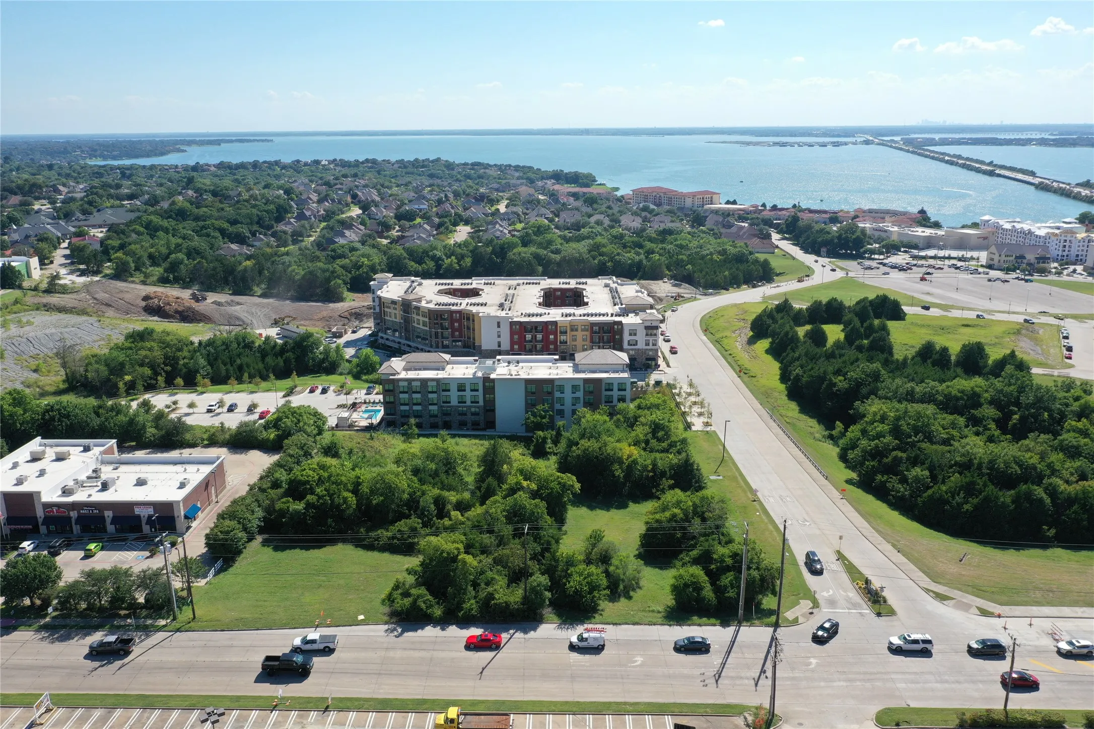 Modern residential complex set within expansive landscaped grounds featuring mature tree coverage, manicured lawn areas, and professional hardscaping