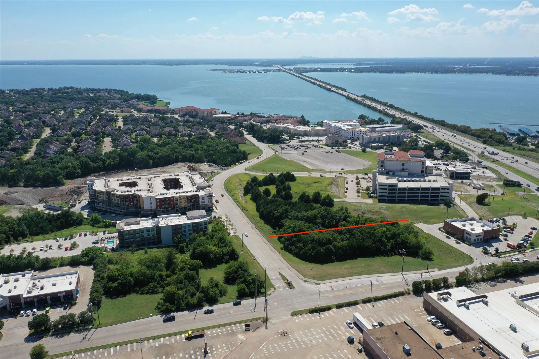 Aerial view showcasing this waterfront property's prime location with expansive manicured grounds, mature landscaping, and modern institutional architecture