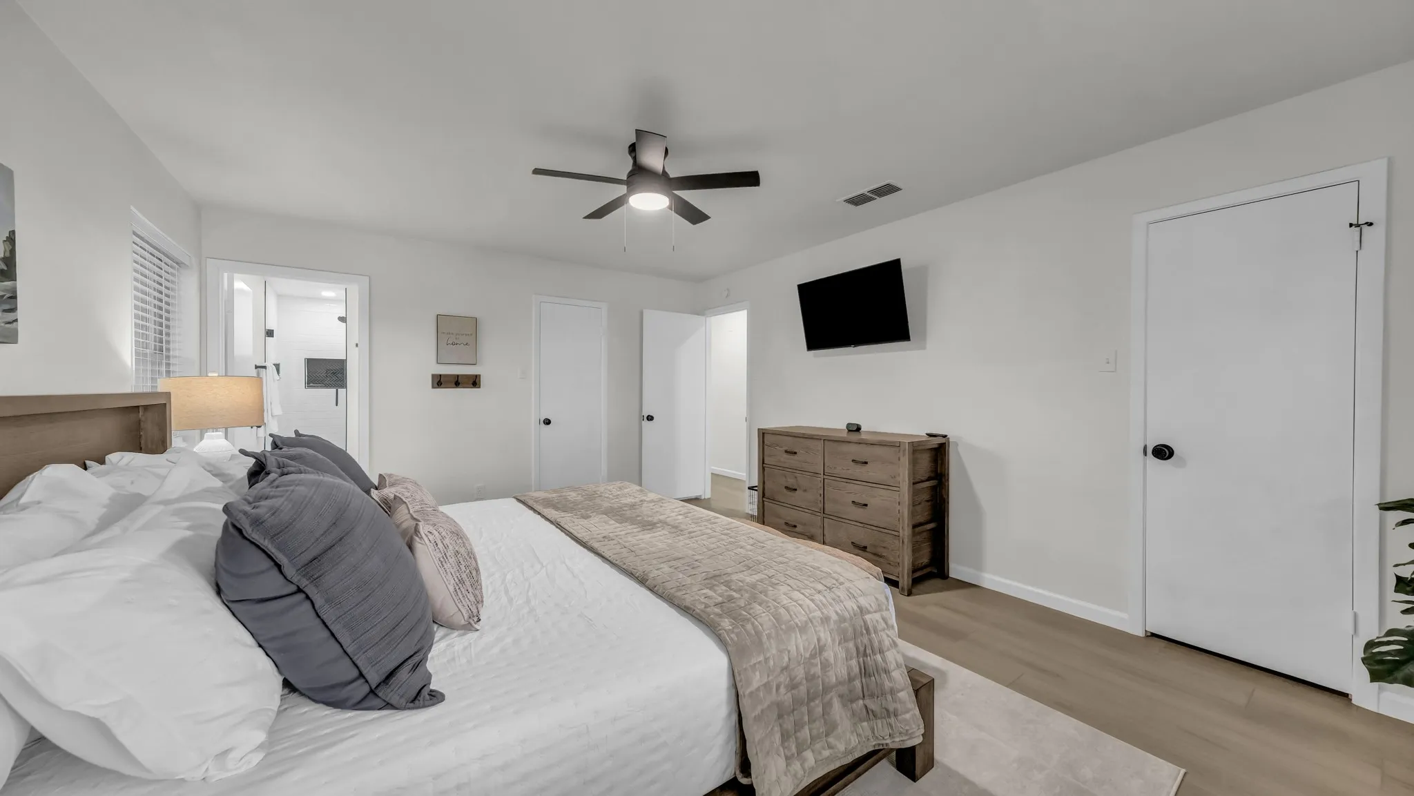 Primary bedroom with comfy king size bed and plenty of extra pillows, blankets and sheets. Closet with hangers and dresser ready for you to stay a while! Private bathroom off of primary bedroom.