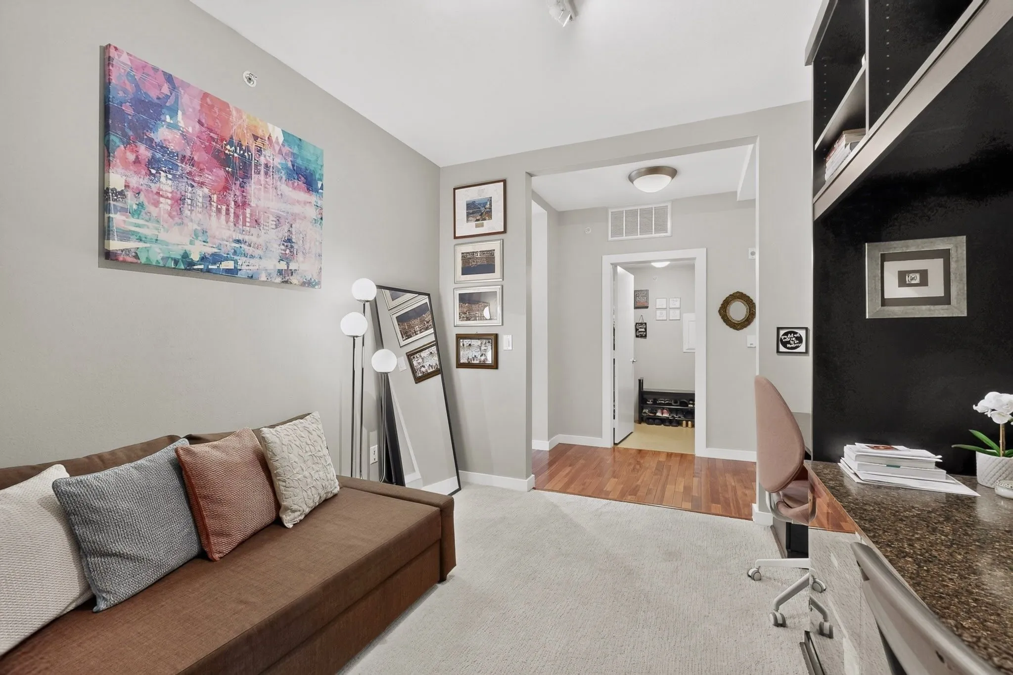 Dedicated office area featuring a built-in black shelving unit and a granite-finish desk