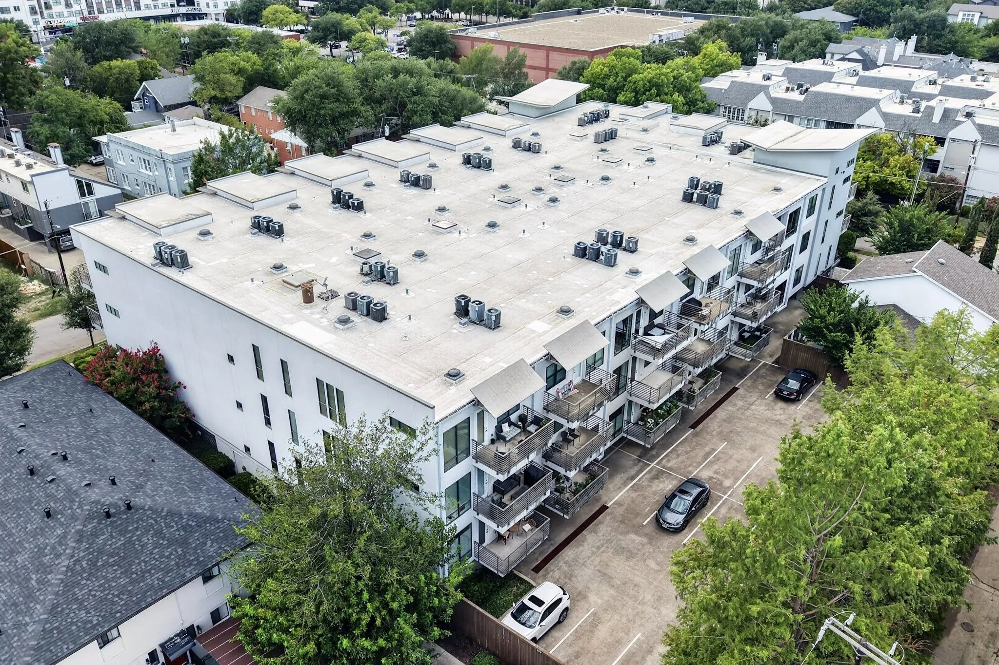 Modern multi-story building featuring a flat roofline and integrated outdoor balconies