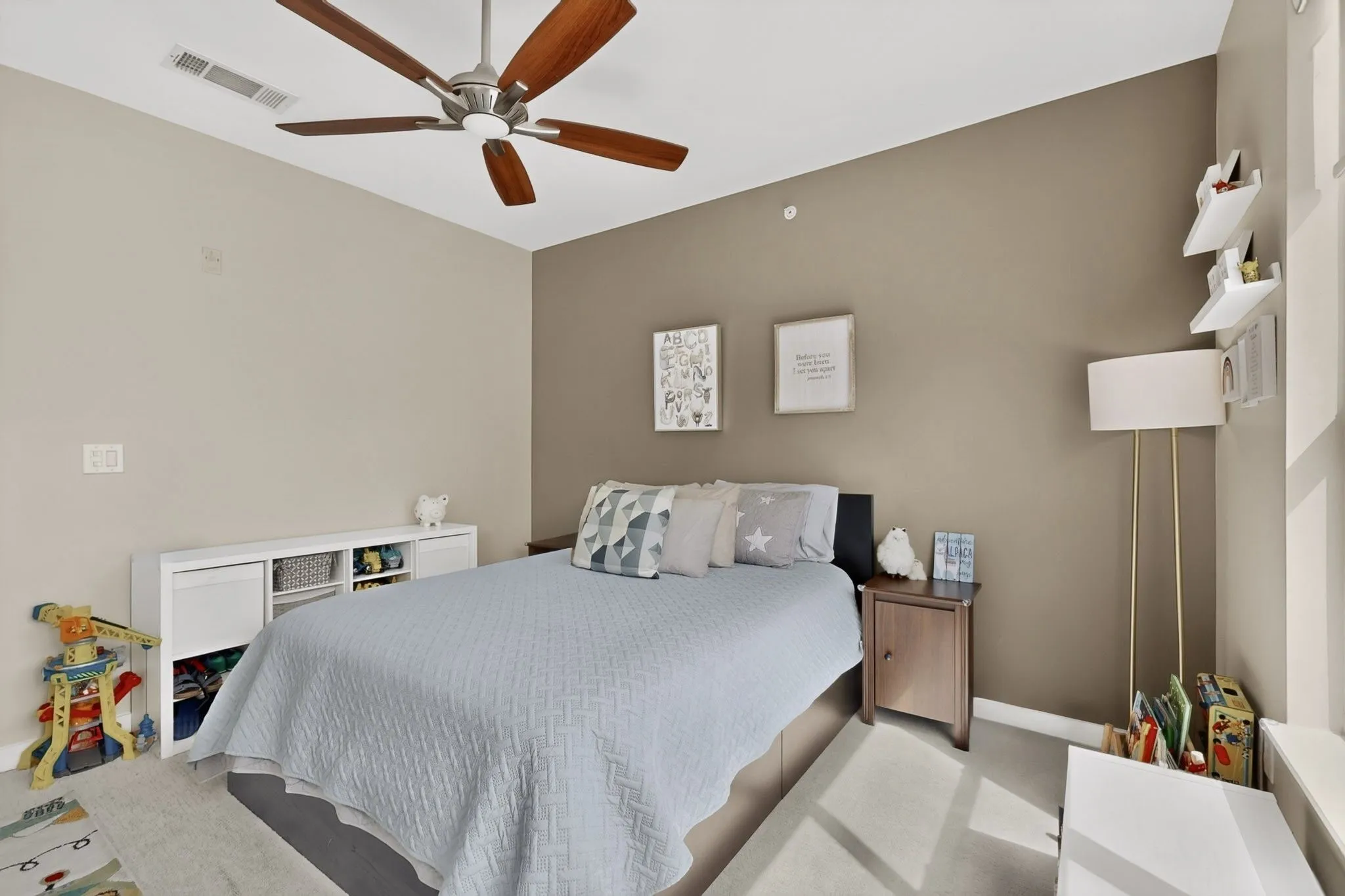 Neutral painted walls, a vaulted ceiling, and a ceiling fan with wood-finish blades