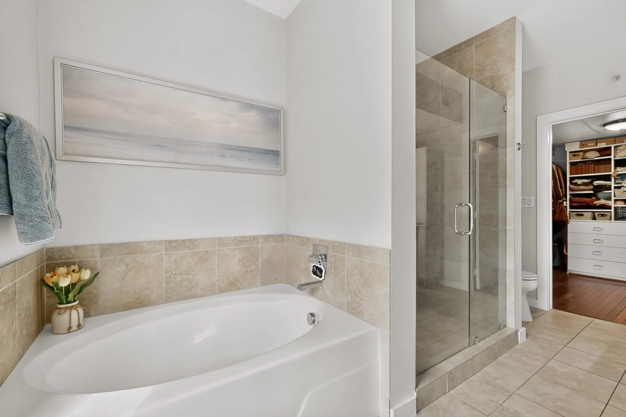 Bathroom featuring a built-in soaking tub with tiled surround, a glass-enclosed shower, and tile flooring
