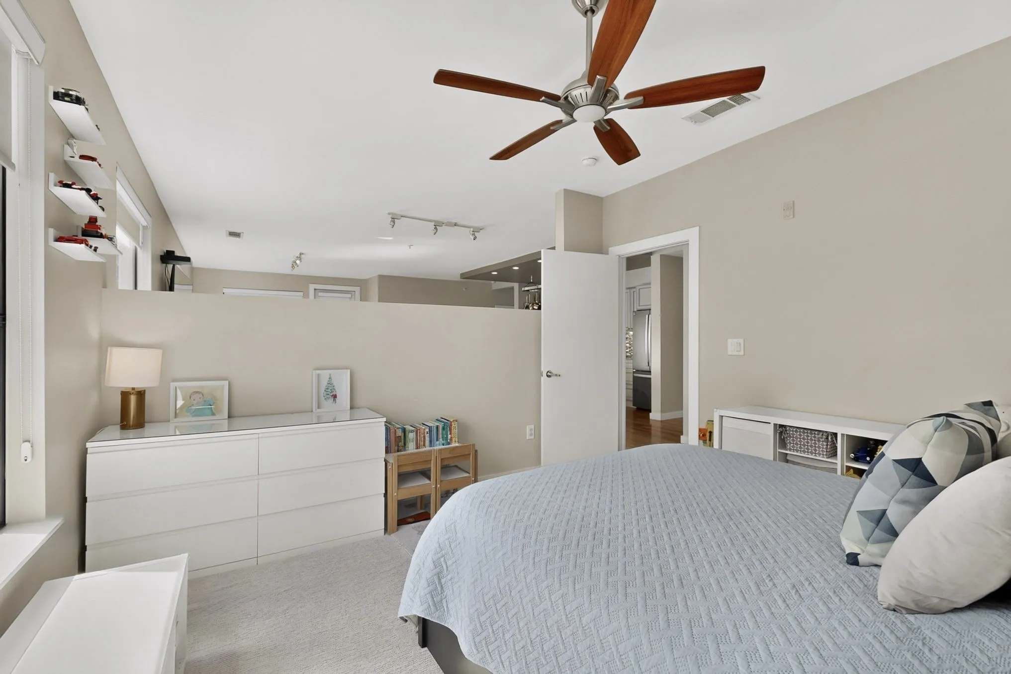 Bedroom featuring a ceiling fan with wood-finish blades, neutral wall tones, and carpet flooring