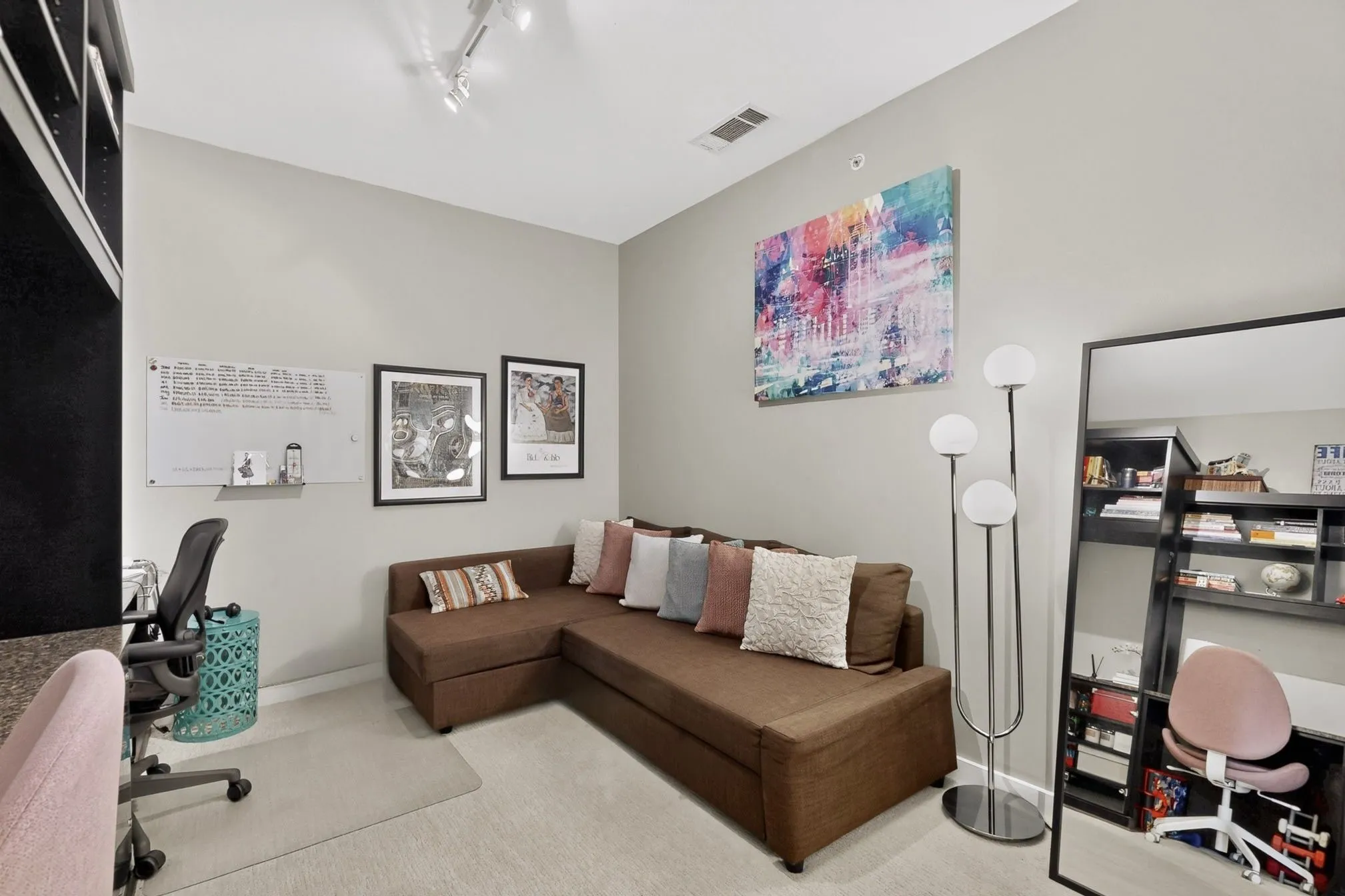 Versatile interior space featuring light gray walls, track lighting, and soft carpet flooring