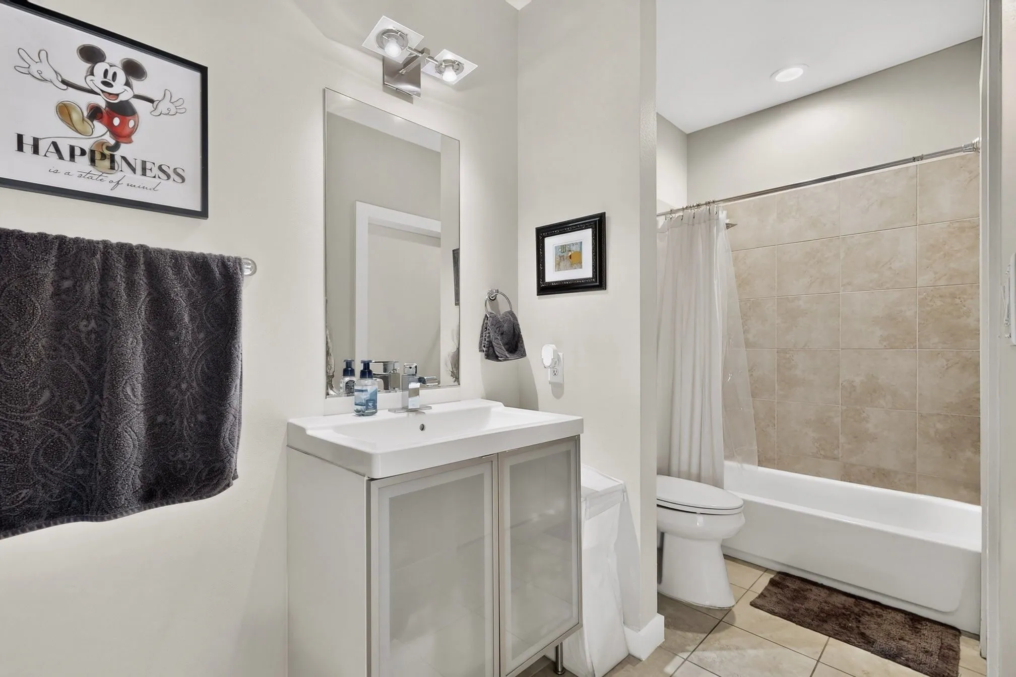 Contemporary bathroom featuring a white vanity with integrated sink, brushed nickel faucet, and a large wall mirror
