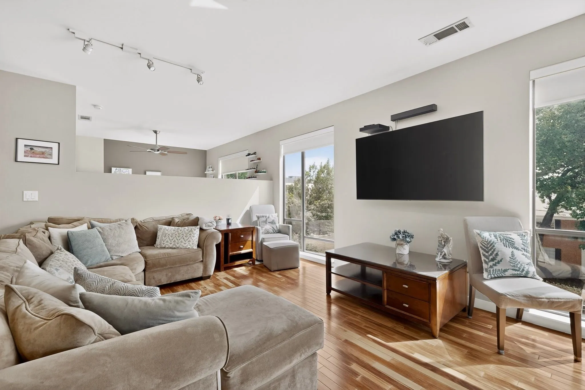 Living area featuring wood-finish flooring, track lighting, and a partial open-concept layout