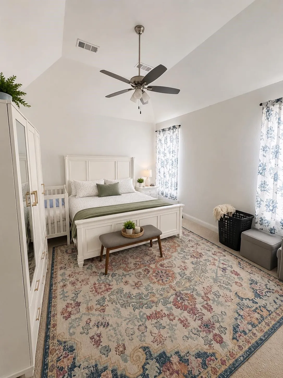 Vaulted ceiling with an attached ceiling fan, two windows with curtain rods, and carpet flooring