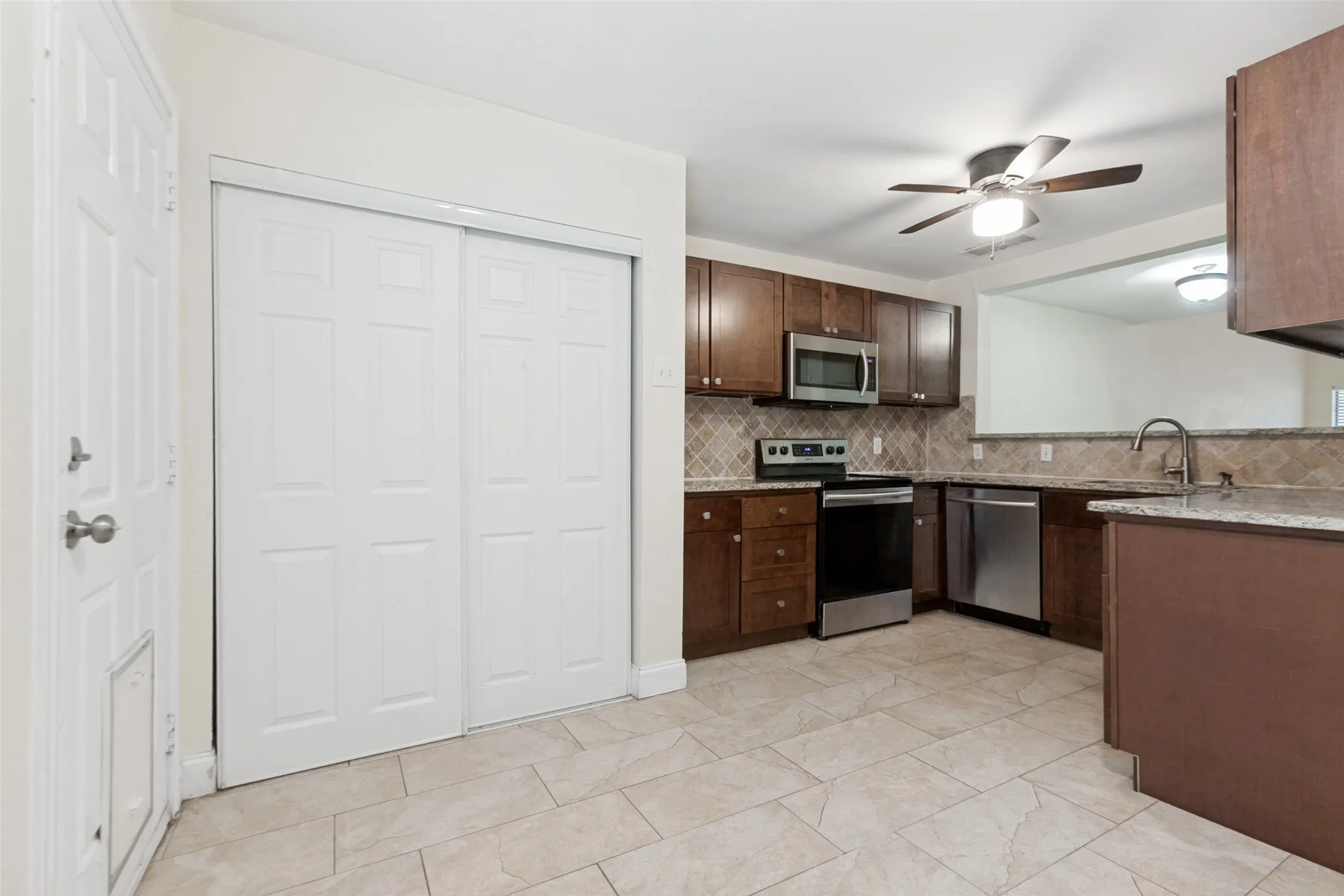 Kitchen featuring wood cabinetry, stainless steel appliances, and a tiled backsplash
